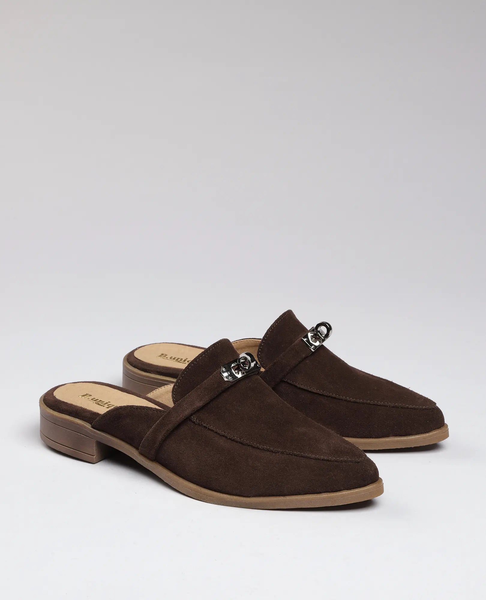 זוג כפכפי מוקסין- ניקי מבית B.unique — נעלי מוקסין מזמש עם אבזמים כסופים ועקבים נמוכים על רקע חלק.