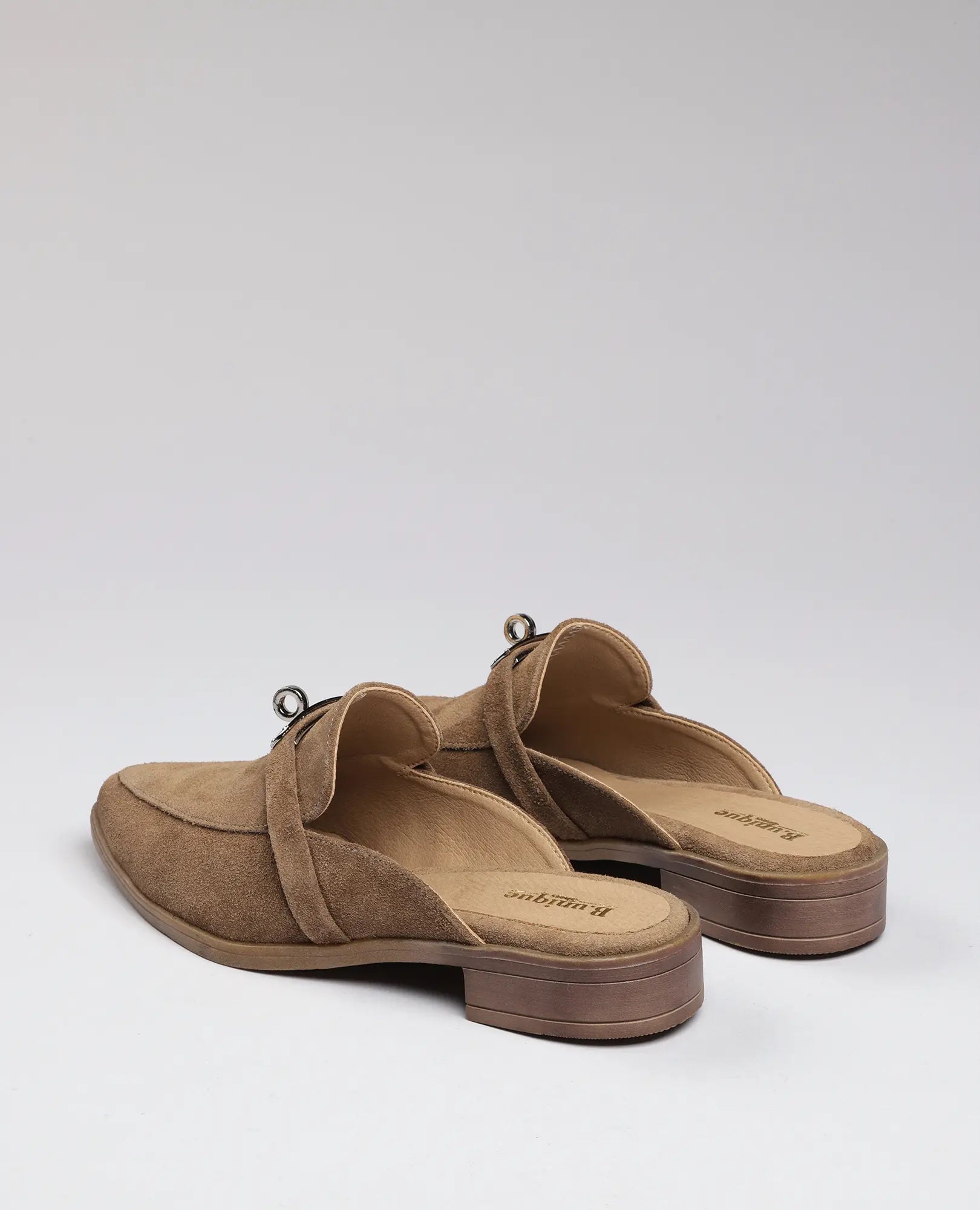 כפכפי מוקסין-ניקי מעור זמש בצבע טאן עם עקב עץ נמוך של B.unique, מצולמות מהגב על רקע בהיר.