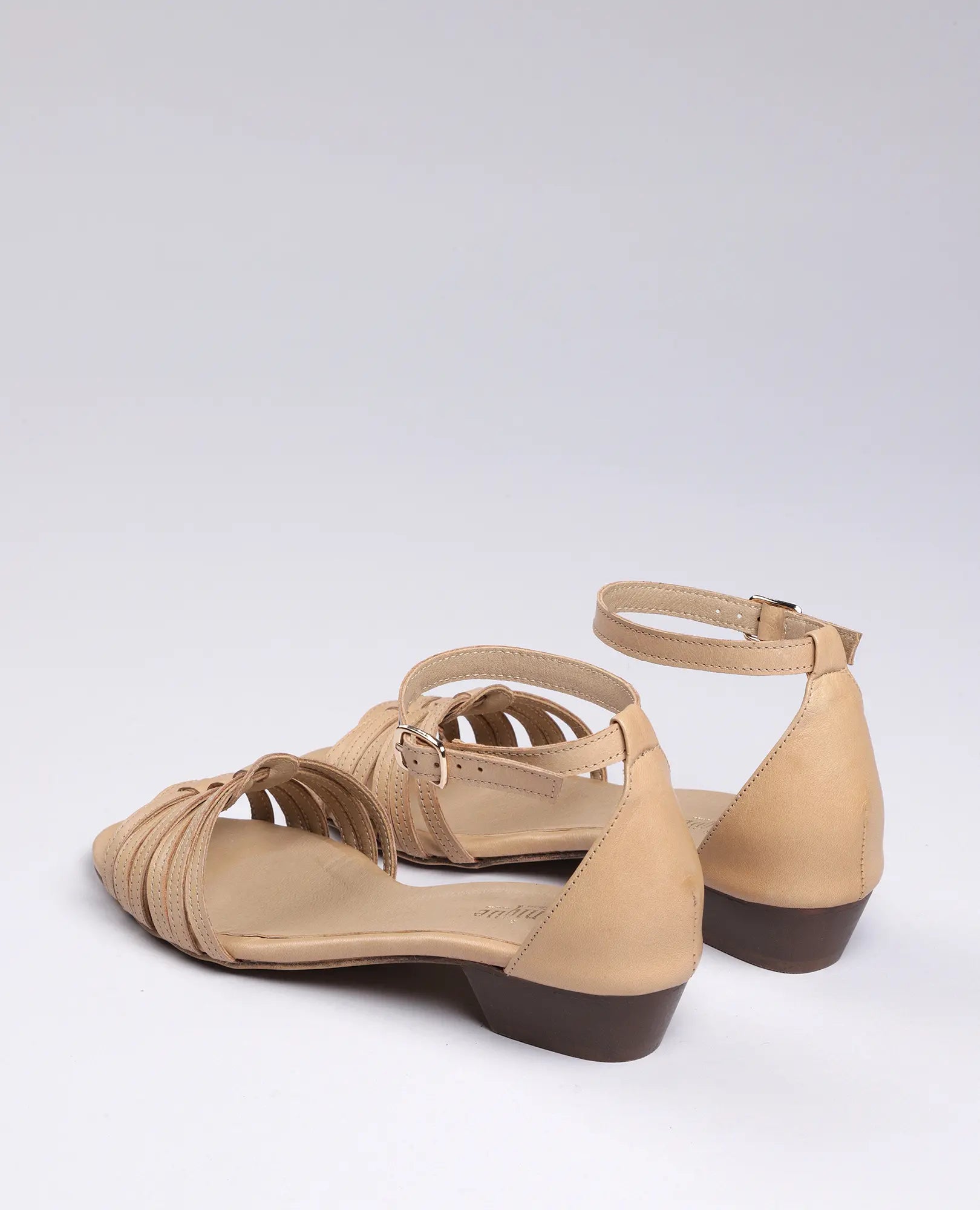 סנדלי רצועות דקות של B.unique לנשים בצבע בז', בעיצוב קלאסי עם עקבים חומים נמוכים.