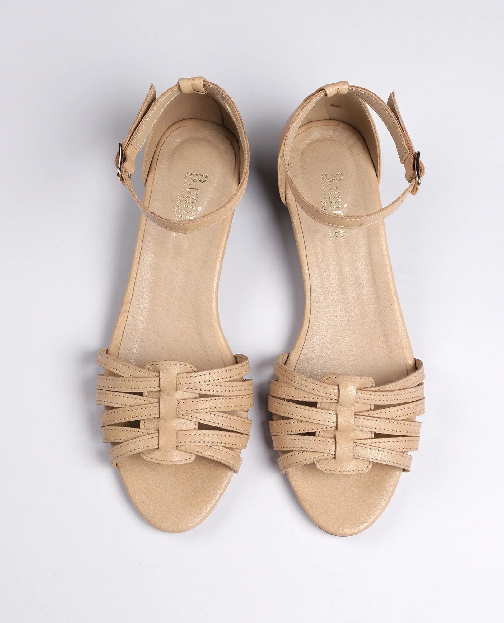 סנדלי רצועות דקות מבית B.unique, בצבע קאמל, שטוחים עם אבזמים ובעיצוב קלאסי.
