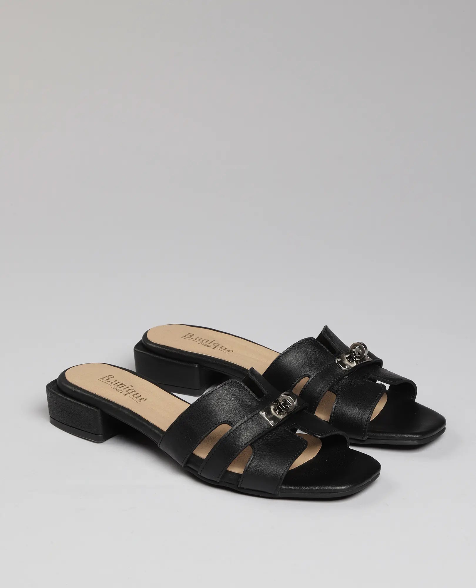 כפכפי רצועות עם אבזם – דגם "נעה" של B.unique, סנדלים שחורים, עקב נמוך ורצועות רחבות עם אבזמי מתכת.