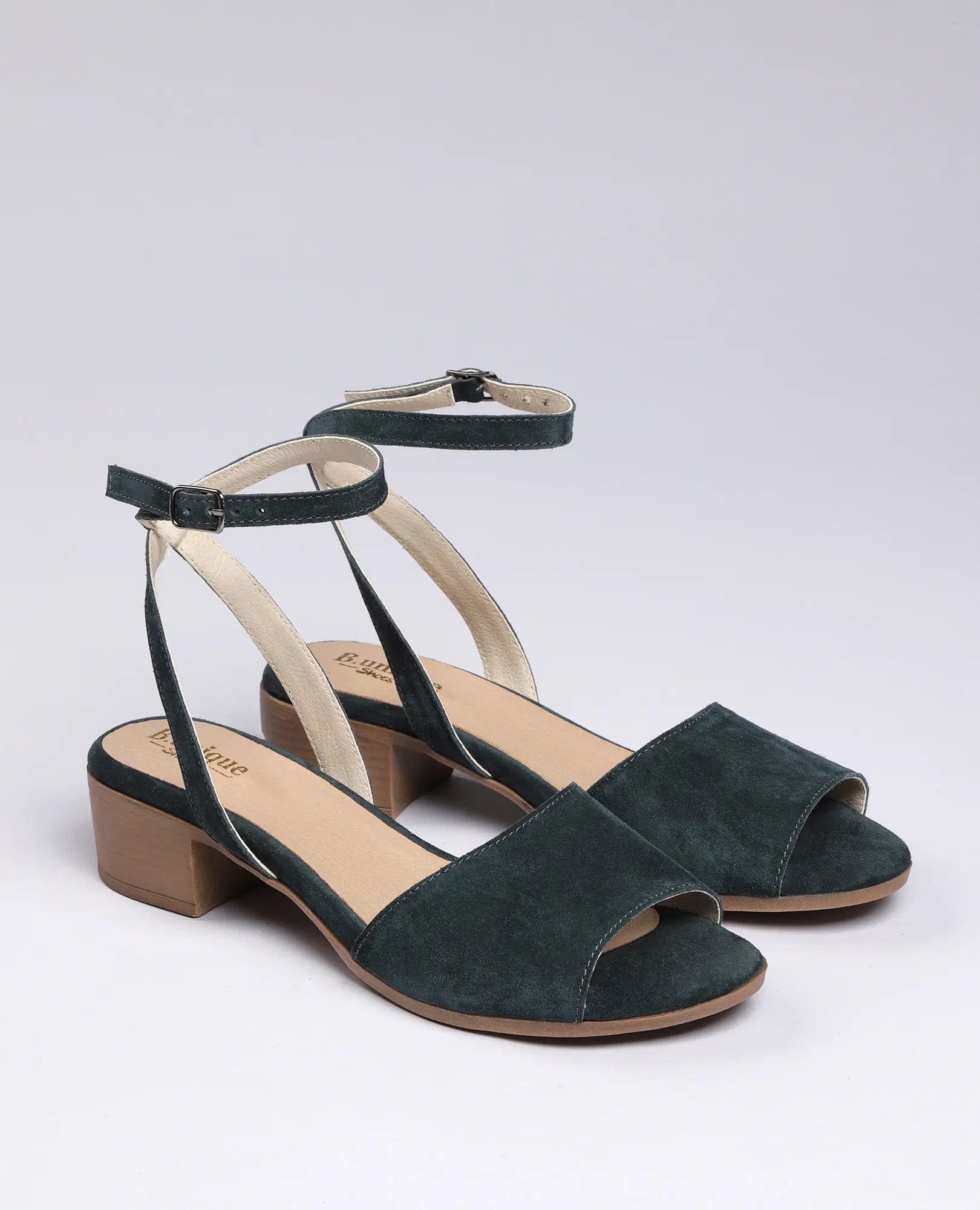 סנדלי פלה מזמש-סנואו בצבע ירוק לנשים מבית B.unique, עם רצועות קרסול ועקבים נמוכים בעיצוב פתוח.