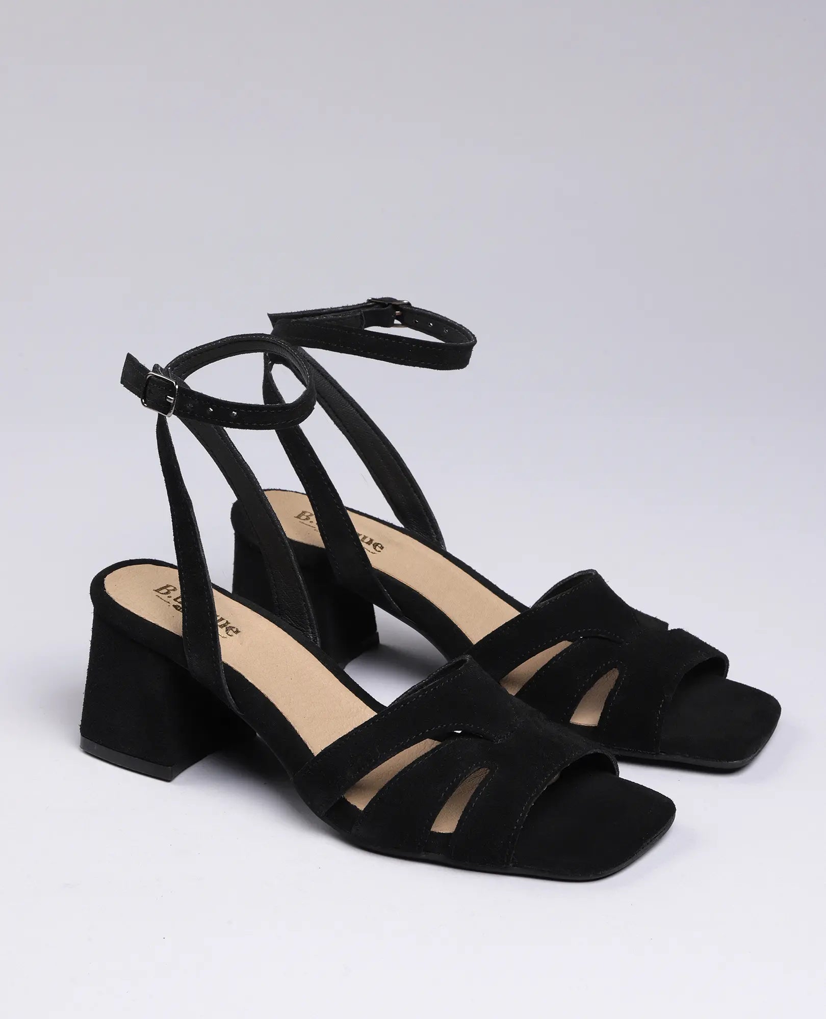 סנדלי עקב "ארבל" של B.unique מעור זמש שחור עם רצועת קרסול ופתוחים מקדימה, על רקע בהיר.