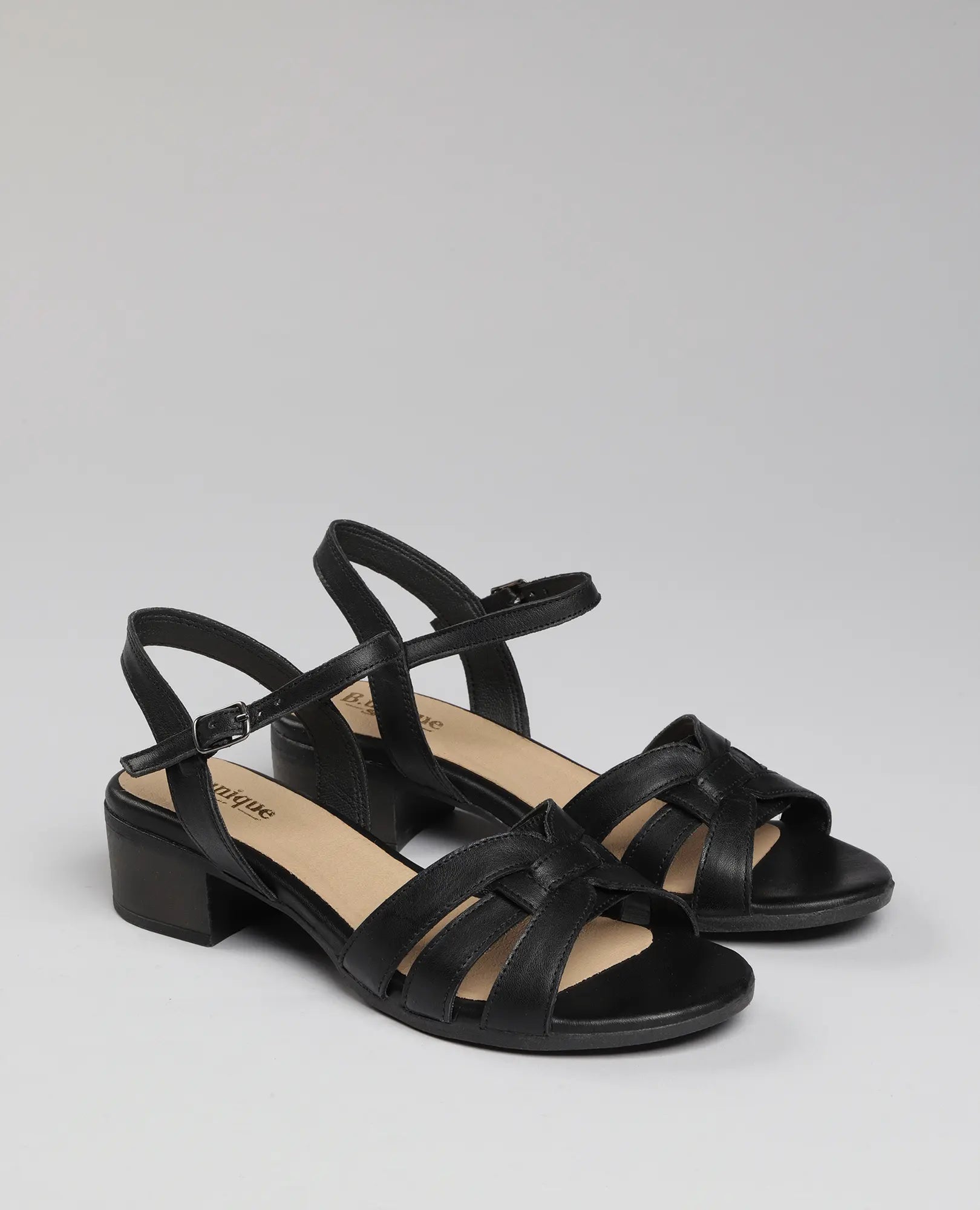 זוג סנדלי עקב שחורים מדגם "מאור" של B.unique, עם רצועות בקרסול ועקבים נמוכים, מוצגים על רקע בהיר אחיד.