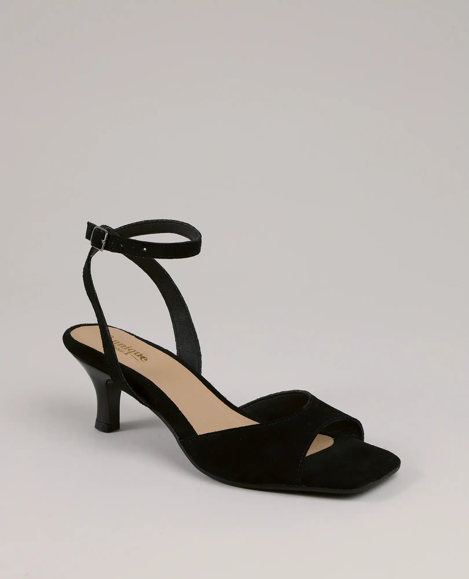 סנדלי עקב - נייה מבית B.unique: סנדל עקב פתוח בצבע שחור מעור זמש עם רצועת קרסול ועקב נמוך על רקע חלק.