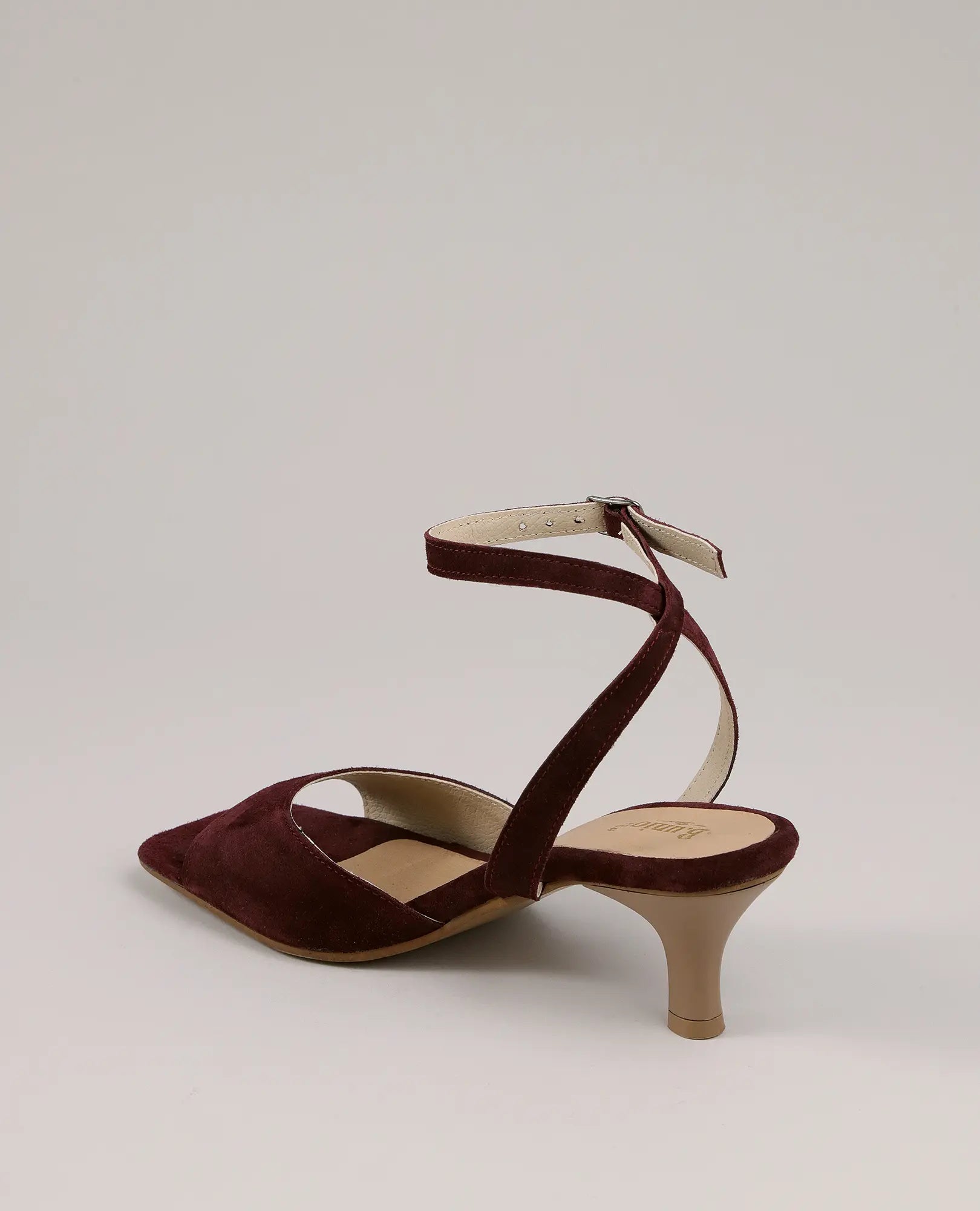 סנדלי עקב של המותג B.unique מעור זמש בורדו, עם רצועת קרסול ועקב מחודד, מוצגים על רקע חלק.