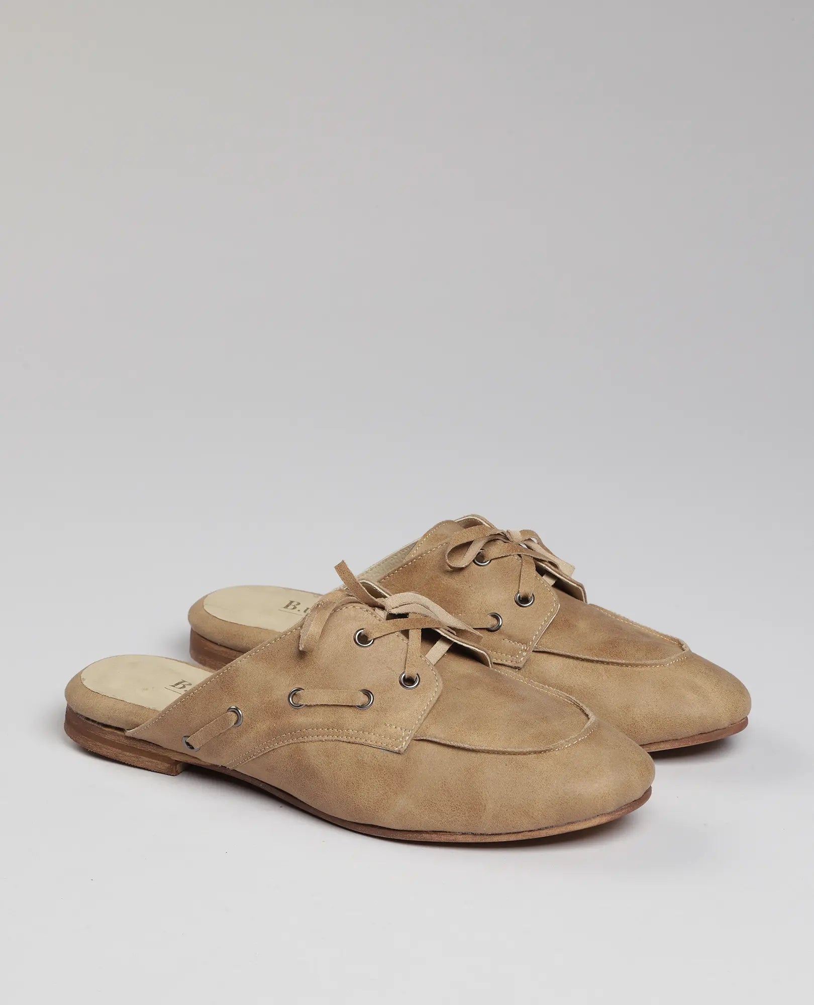 כפכפי מוקסין- לירי של B-Unique VEGAN בעיצוב דמוי עור בז' עם סוליות עץ שטוחות, מוצגים על רקע בהיר.