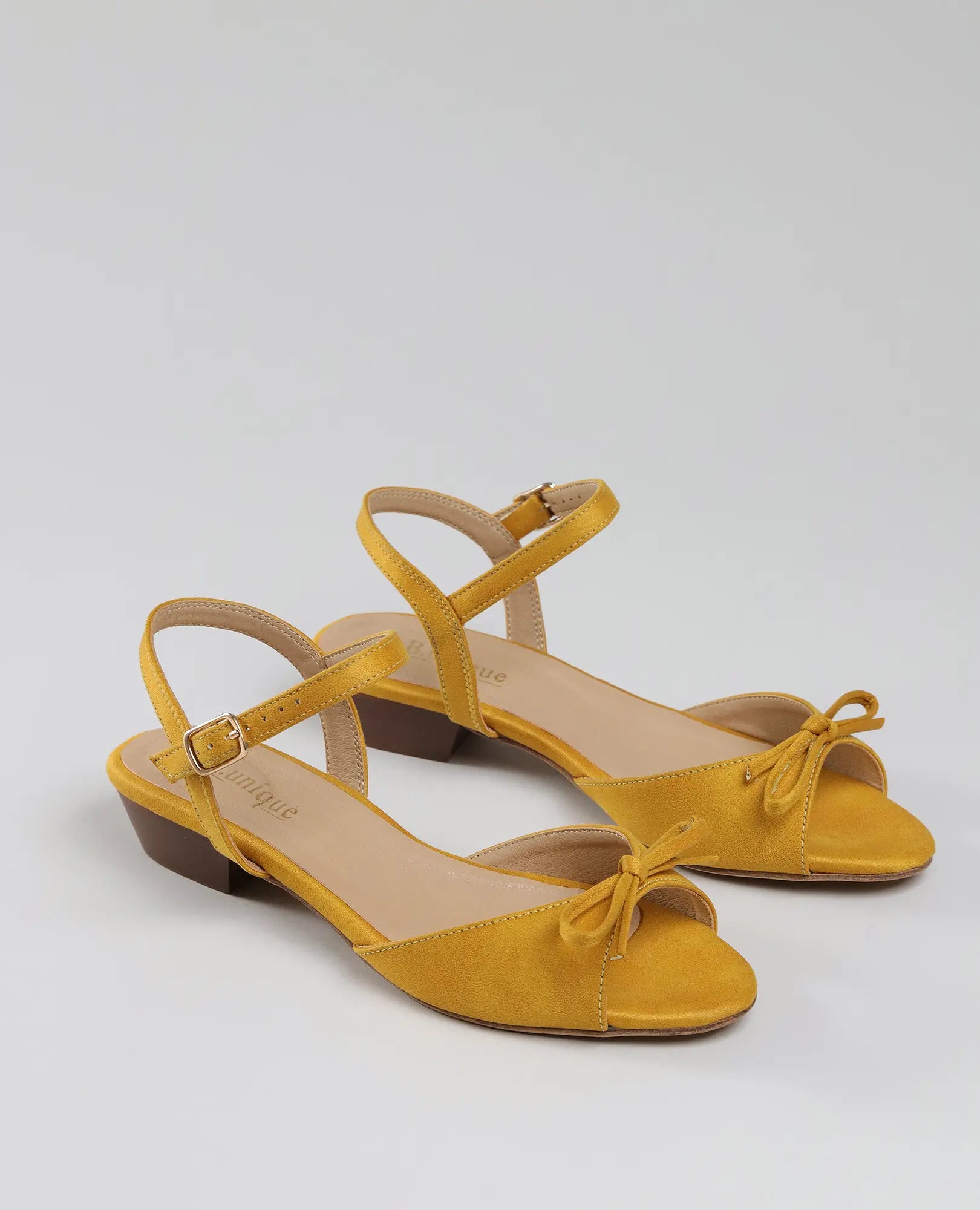 סנדלי פפיון קשורים של B-Unique VEGAN בצבע צהוב, עם עקב נמוך, רצועת קרסול וסגירת אבזם.