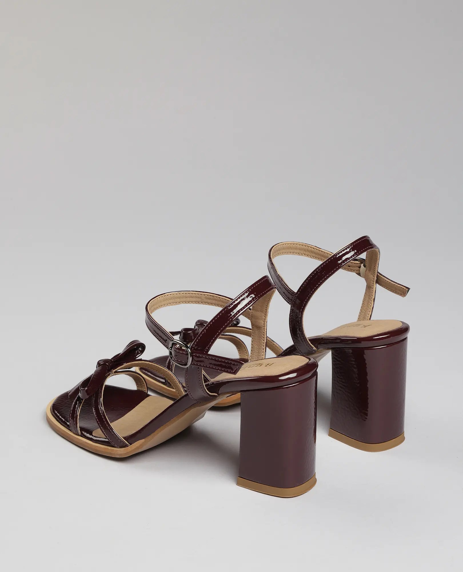 זוג סנדלי עקב B-Unique VEGAN עם רצועת פפיון בצבע בורדו, רצועות מצטלבות ועקב רחב.