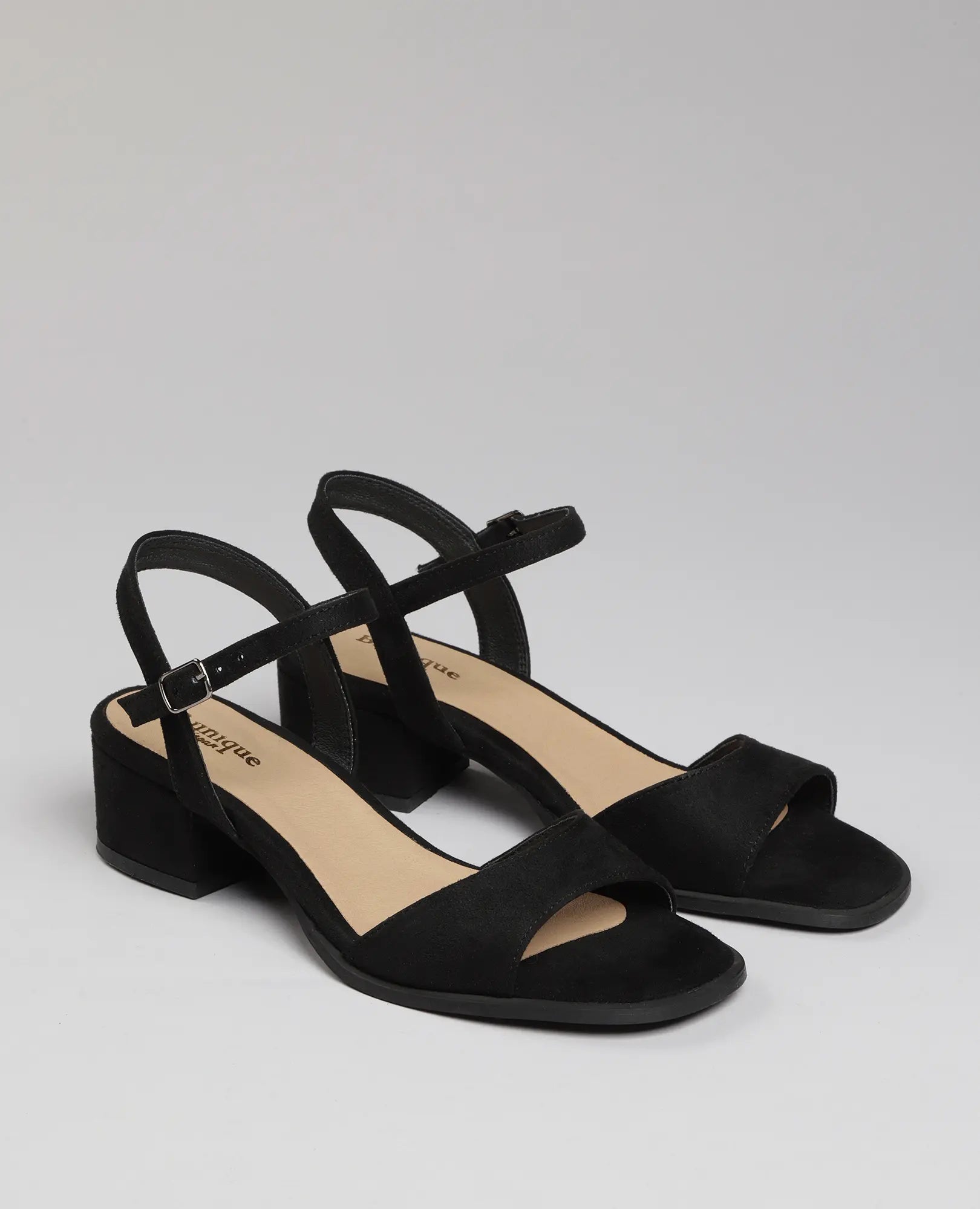 זוג סנדלי עקב "לאב" מבית B-Unique VEGAN בצבע שחור עם רצועות בקרסול על רקע בהיר אחיד.