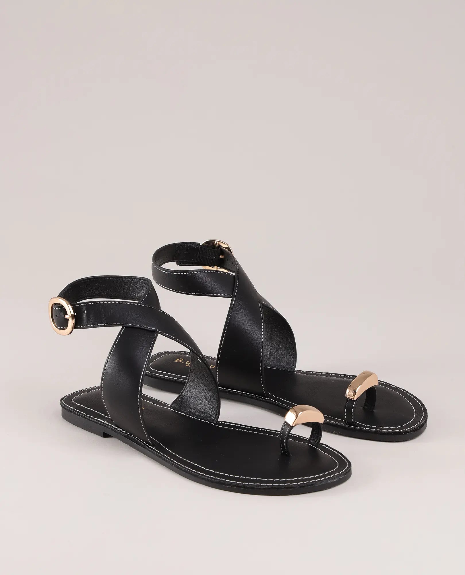 סנדל אצבע עם טבעת של B-Unique VEGAN מעור דמוי עור שחור, עם רצועות קרסול, אבזמים ופרטים מוזהבים.