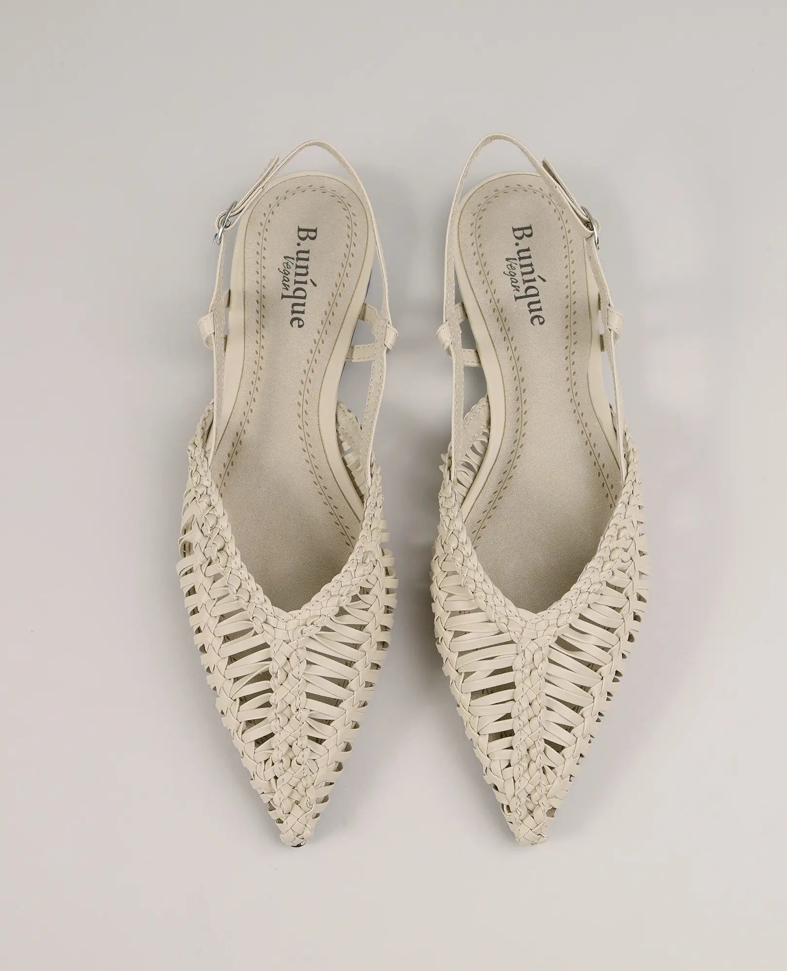 זוג נעליים שטוחות בצבע בז' מבית B-Unique VEGAN, עם עקב פתוח וקצה מחודד, בעיצוב קלוע.