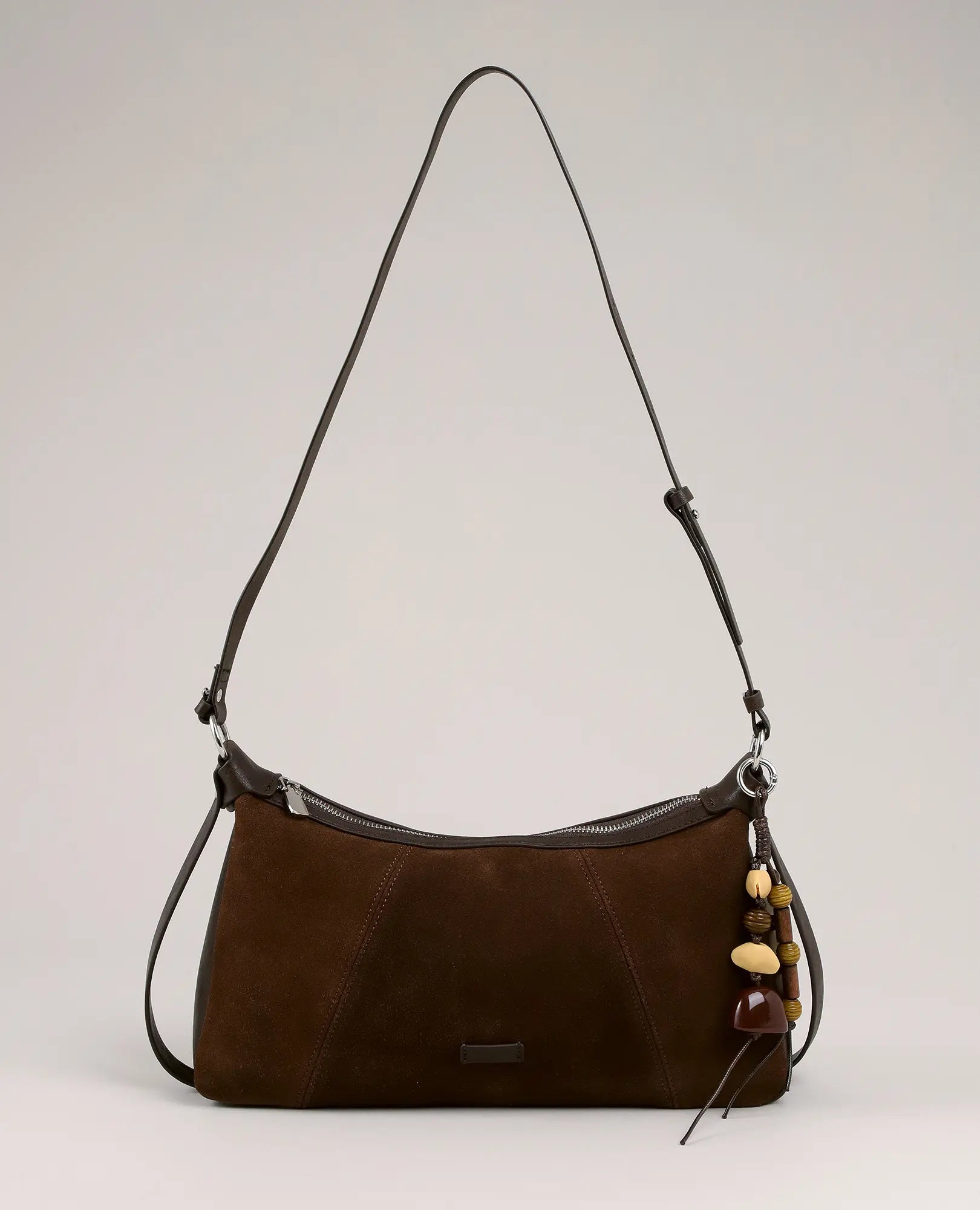 תיק צד מעור זמש - נואל מבית B-Unique Bags עם רצועה ארוכה ותליון מחזיק מפתחות עם חרוזים.