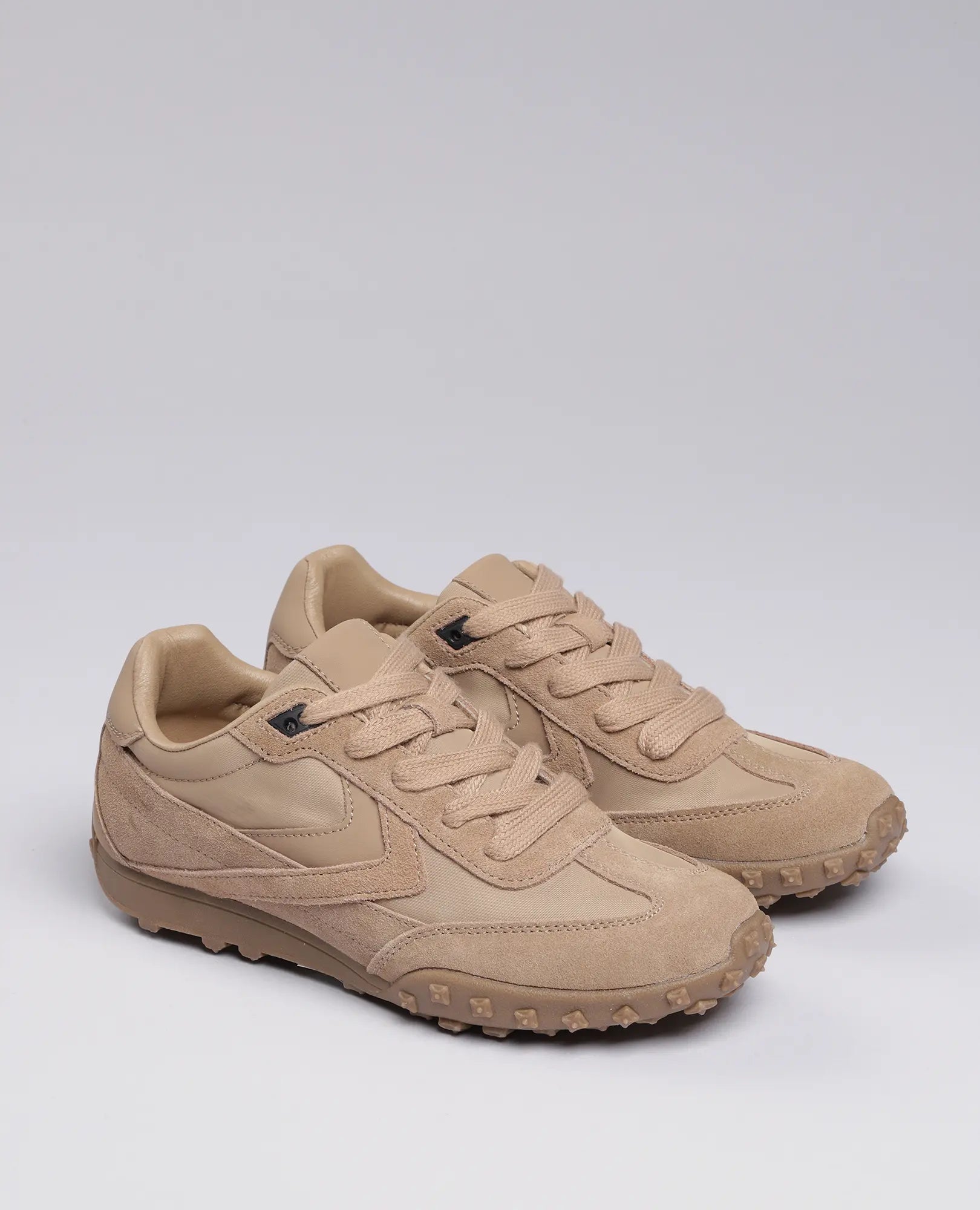 זוג נעלי סניקרס מעור זמש - נטשה עם סוליות מרקמות, מוצגות על רקע בהיר.