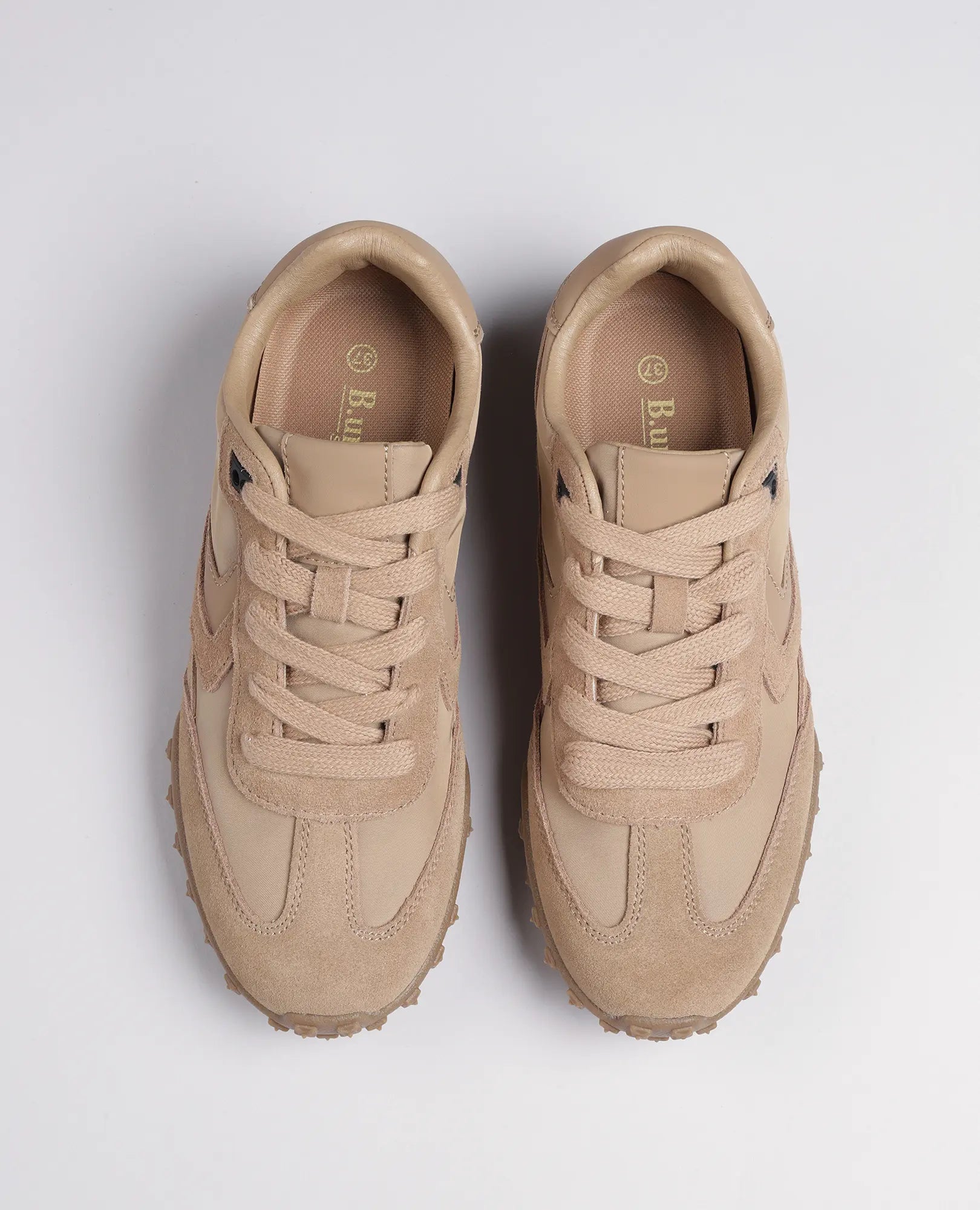 זוג נעלי סניקרס מעור זמש - נטשה מבית B.unique בצבע בז', עם סוליות מרקמות, נראות מלמעלה על רקע לבן.