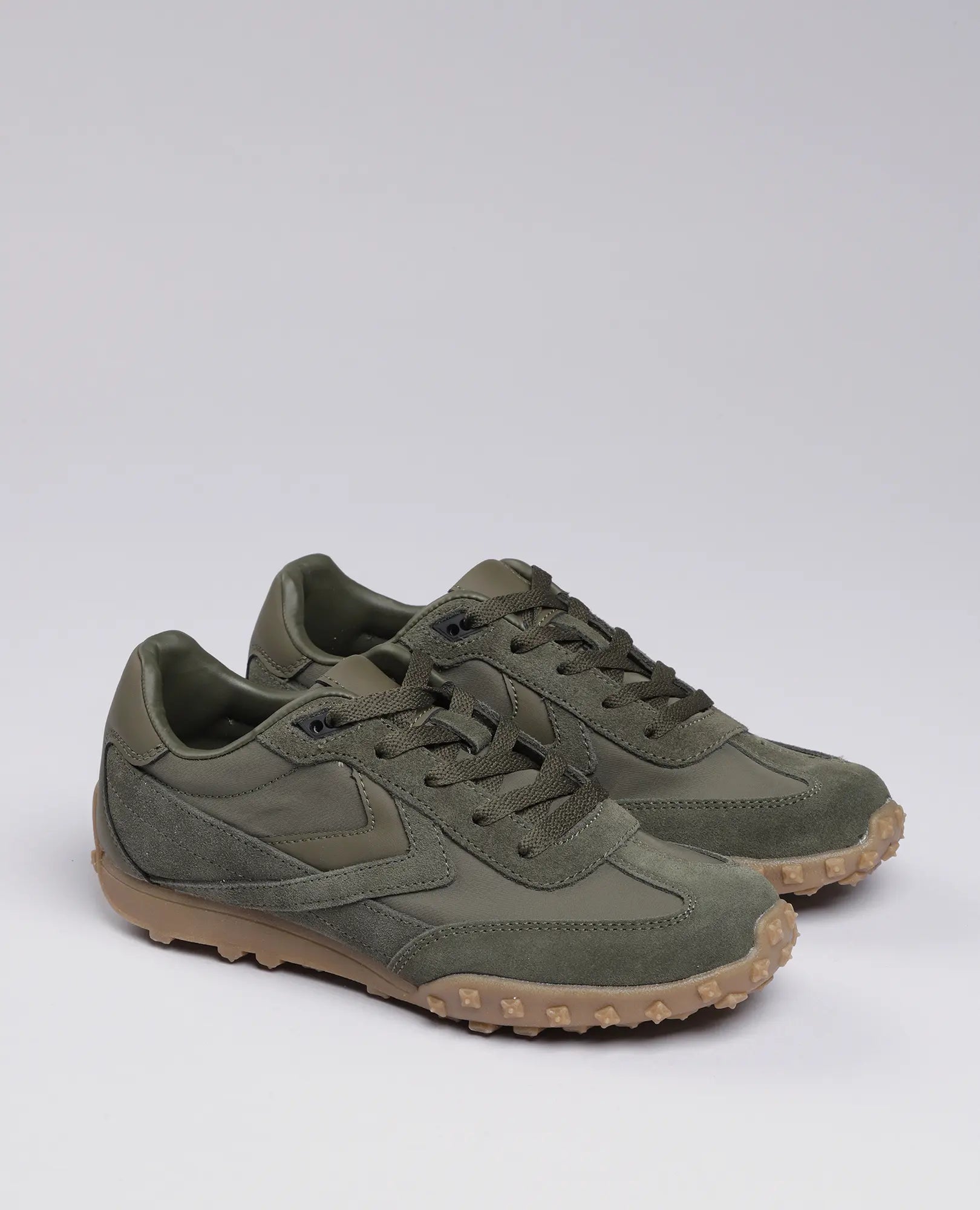 זוג סניקרס מעור זמש- נטשה מבית B.unique בצבע ירוק זית עם סוליות בצבע בז', על רקע בהיר אחיד.