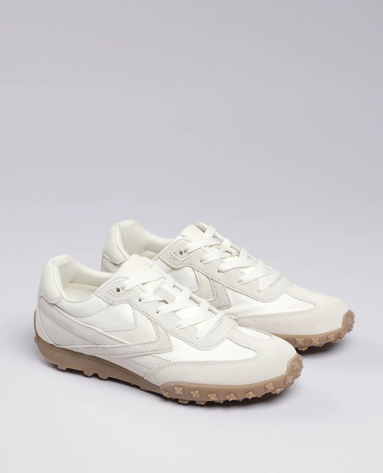 נעלי סניקרס מעור זמש - נטשה של B.unique בצבע לבן עם סוליות בז' ומדרך מחוספס, מוצגות על רקע אפור בהיר.