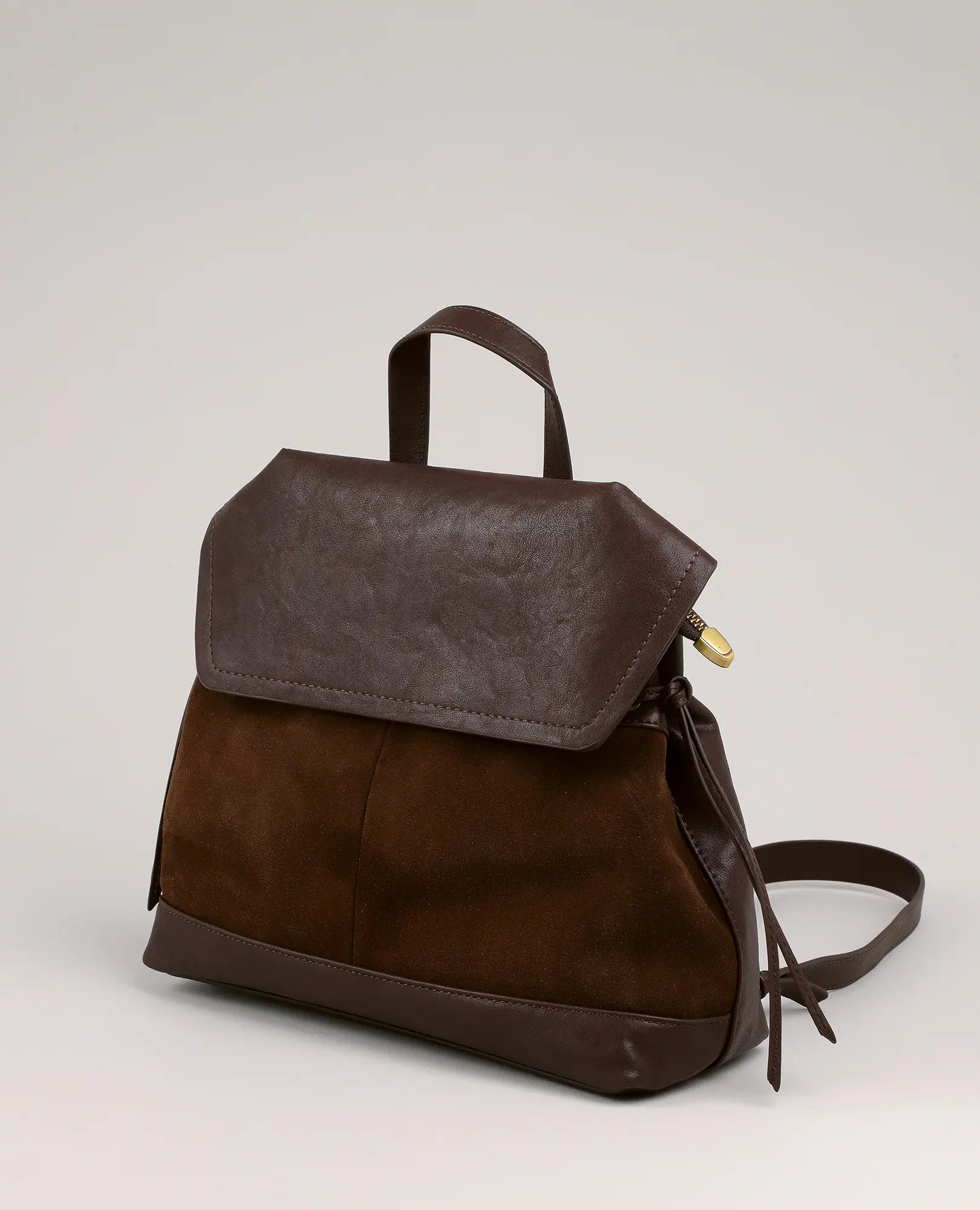 תיק גב-דר של B-Unique Bags, דמוי עור זמש חום עם פפיון, רוכסן זהוב ורצועות מתכווננות.