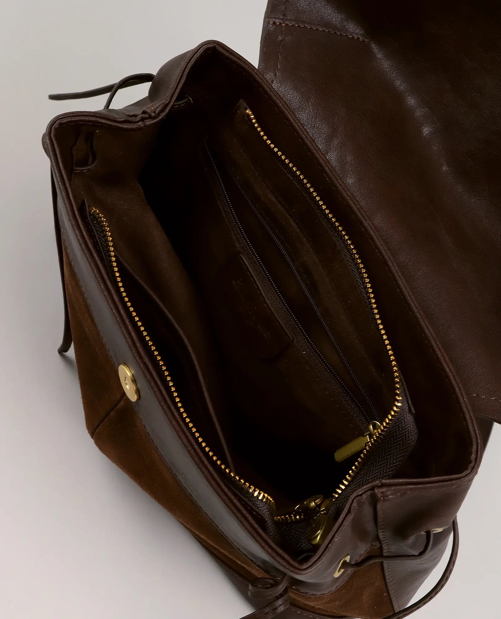 תיק גב דגם "דר" מבית B-Unique Bags, דמוי זמש חום, עם רוכסן, כפתור זהב, כיסים פנימיים וריפוד זמש.