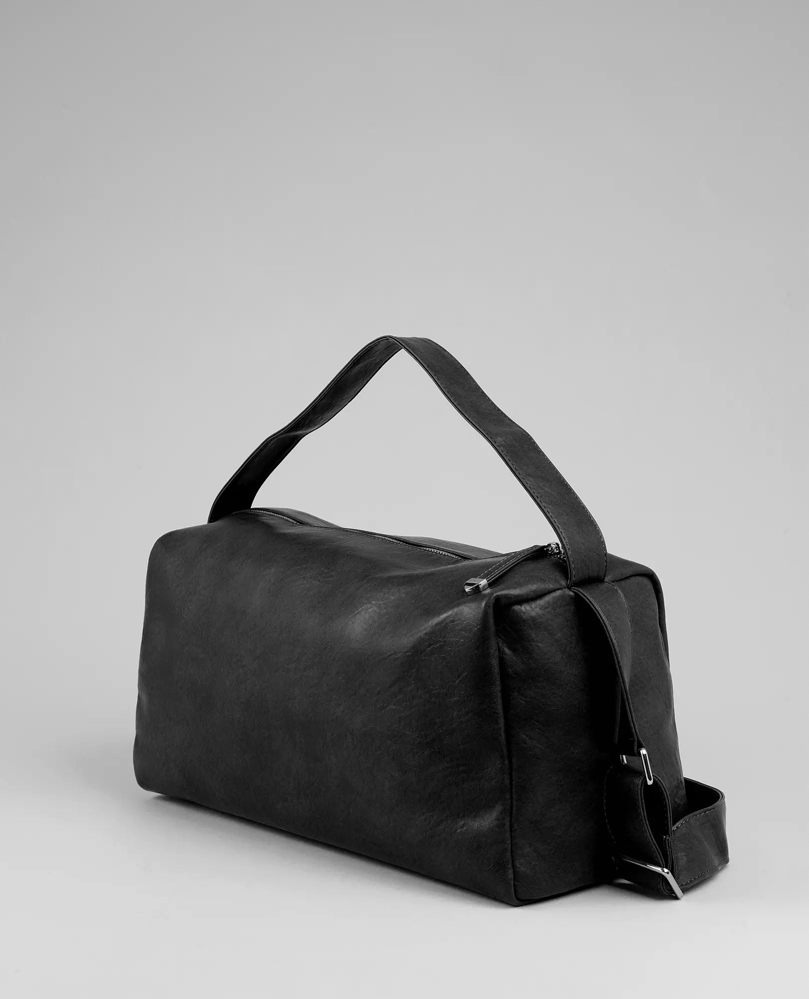 תיק צד רך מדגם "ונסה" מבית B-Unique Bags, דמוי עור שחור עם ידית רחבה ורצועה צדדית על רקע אפור.