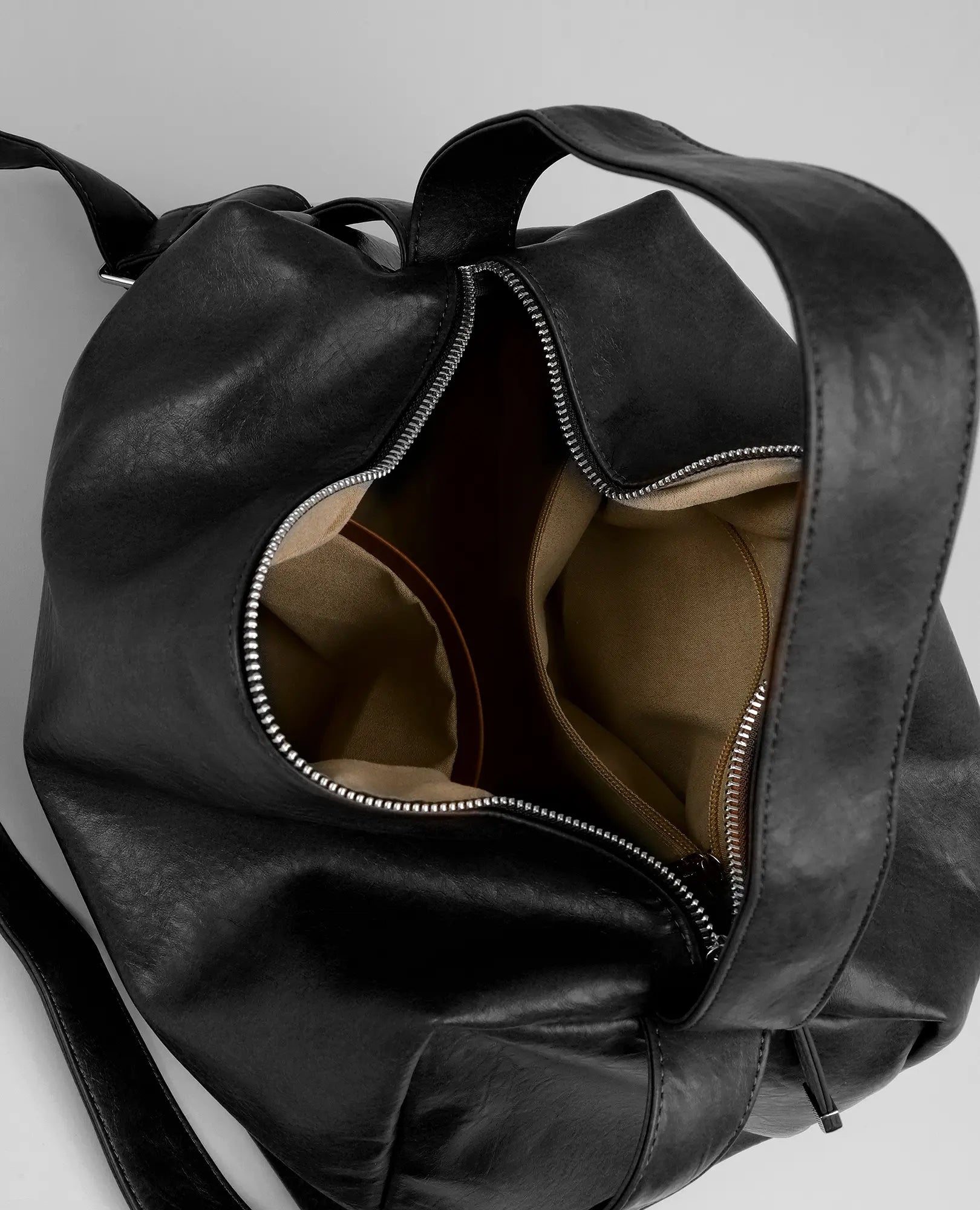 תיק צד רך מדגם "ונסה" של B-Unique Bags, דמוי עור שחור עם רוכסן פתוח חלקית, בטנה בהירה וכיסים פנימיים.