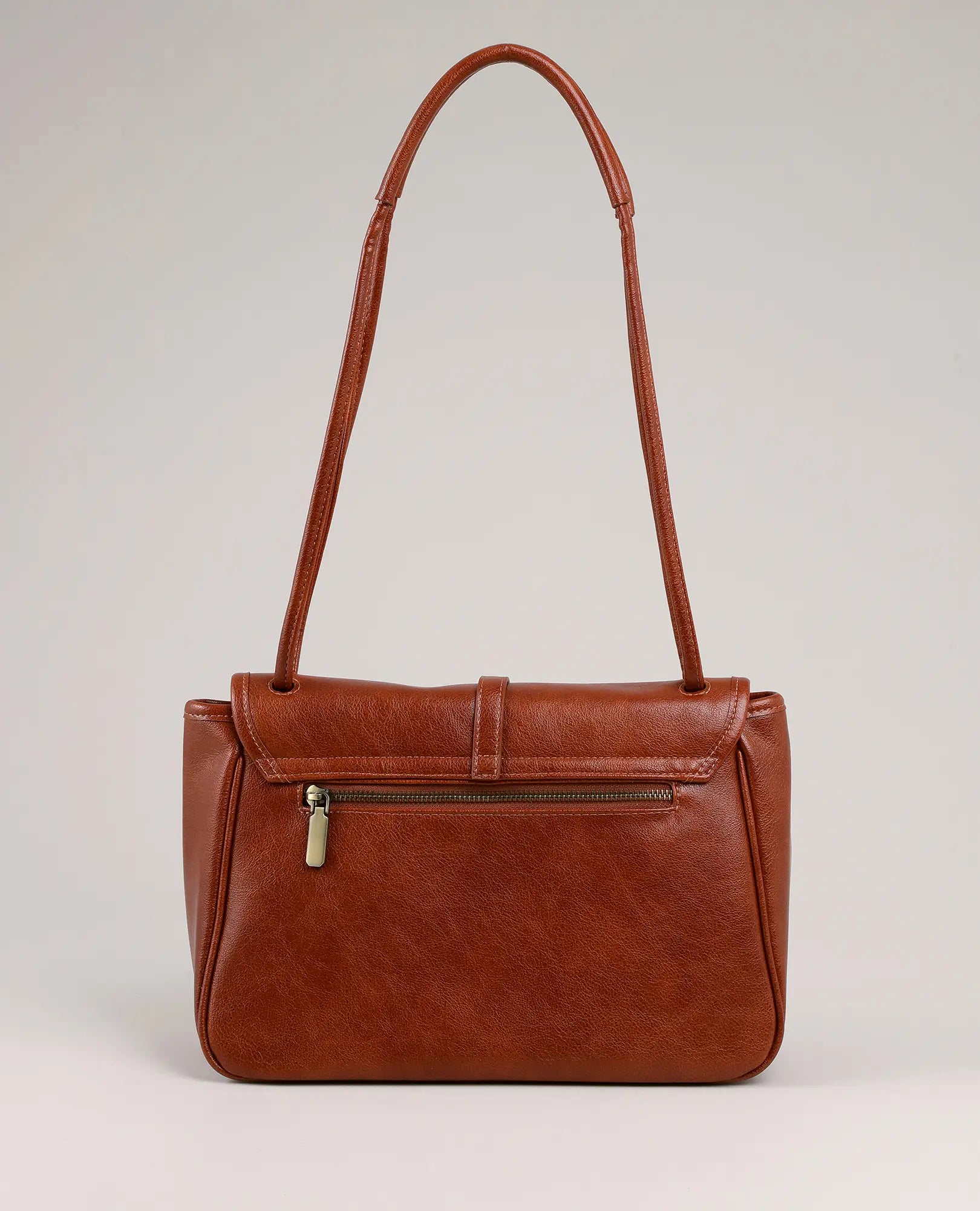 תיק צד עם אבזם טבעת - דגם "סרינה" מבית B-Unique Bags, דמוי עור חום עם רצועה וכיס קדמי עם רוכסן, על רקע אפור.