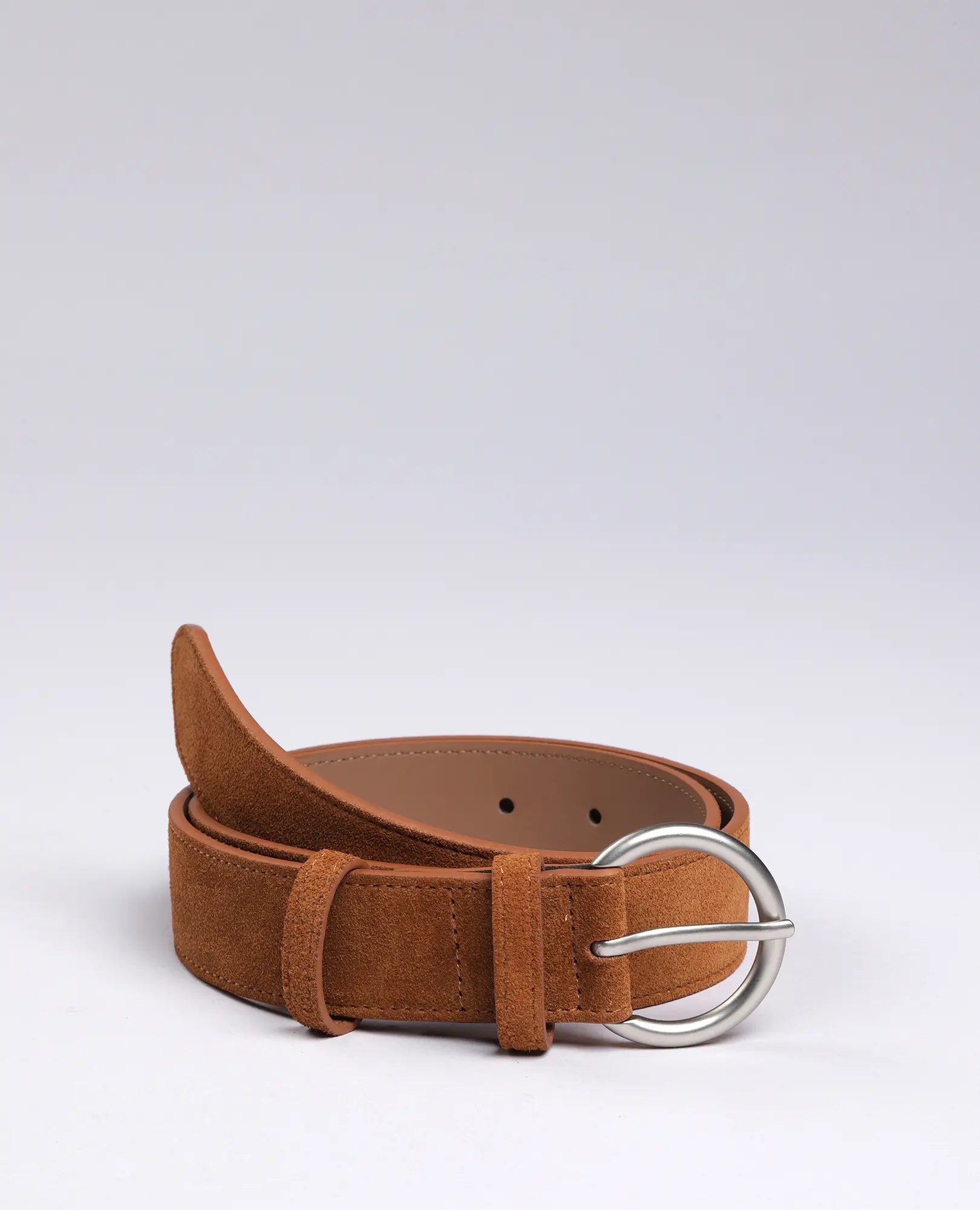 חגורת זמש עם אבזם עגול-מרי בצבע קאמל מבית B Unique מונחת על רקע לבן.