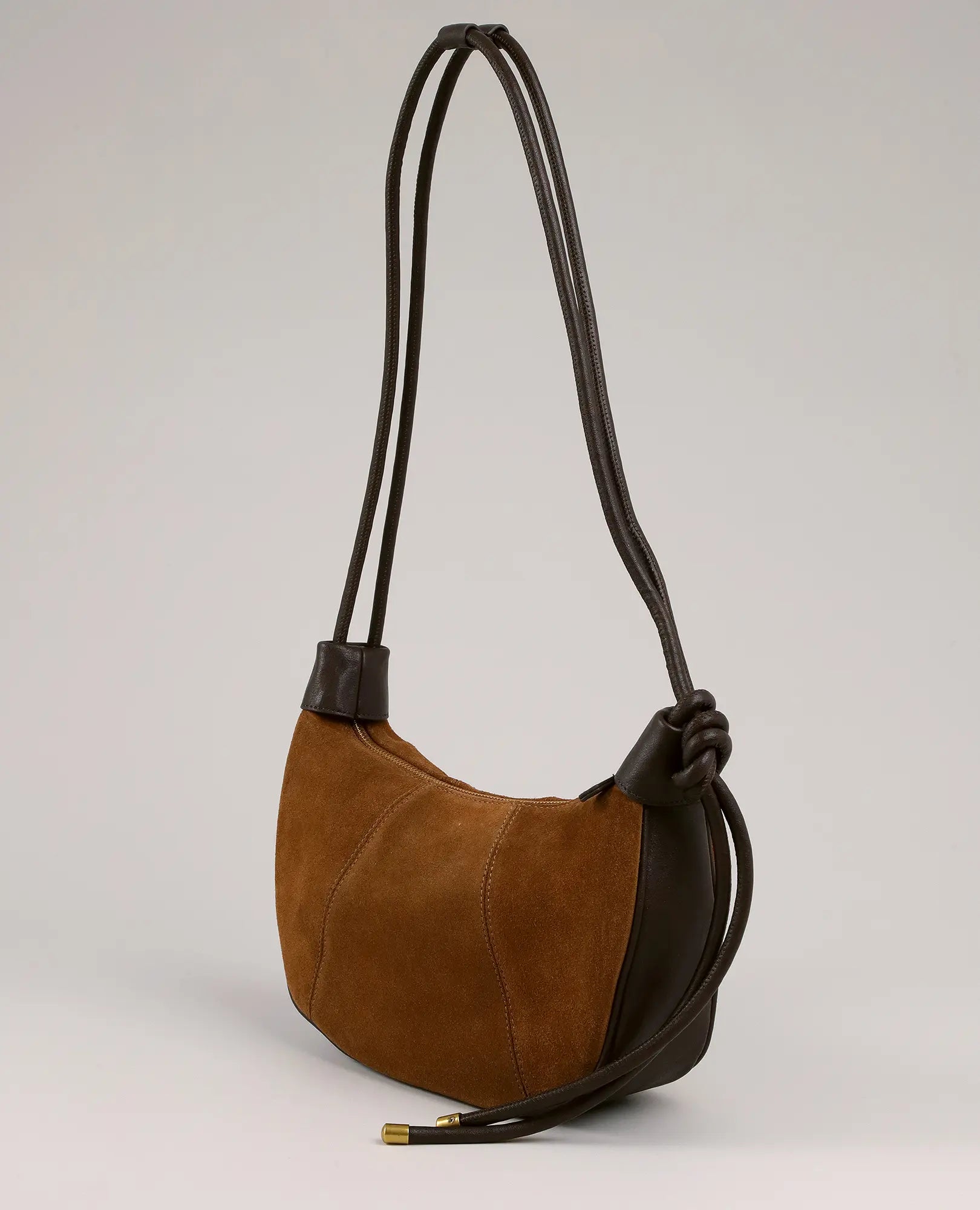 תיק צד - בלייר מבית B-Unique Bags, דגם חצי ירח מעור זמש חום כהה עם רצועה קשורה ועיצוב קשת אלגנטי.