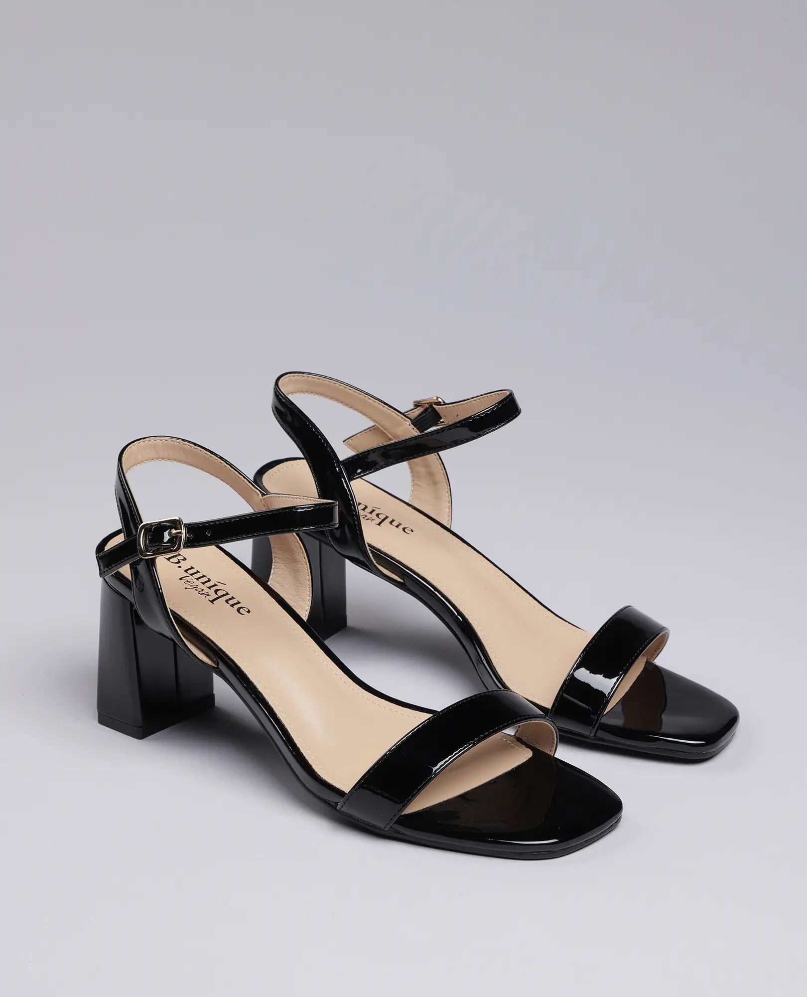 סנדלי עקב אפריל של B-Unique VEGAN, בצבע שחור לק עם רצועות קרסול ועקב רחב.