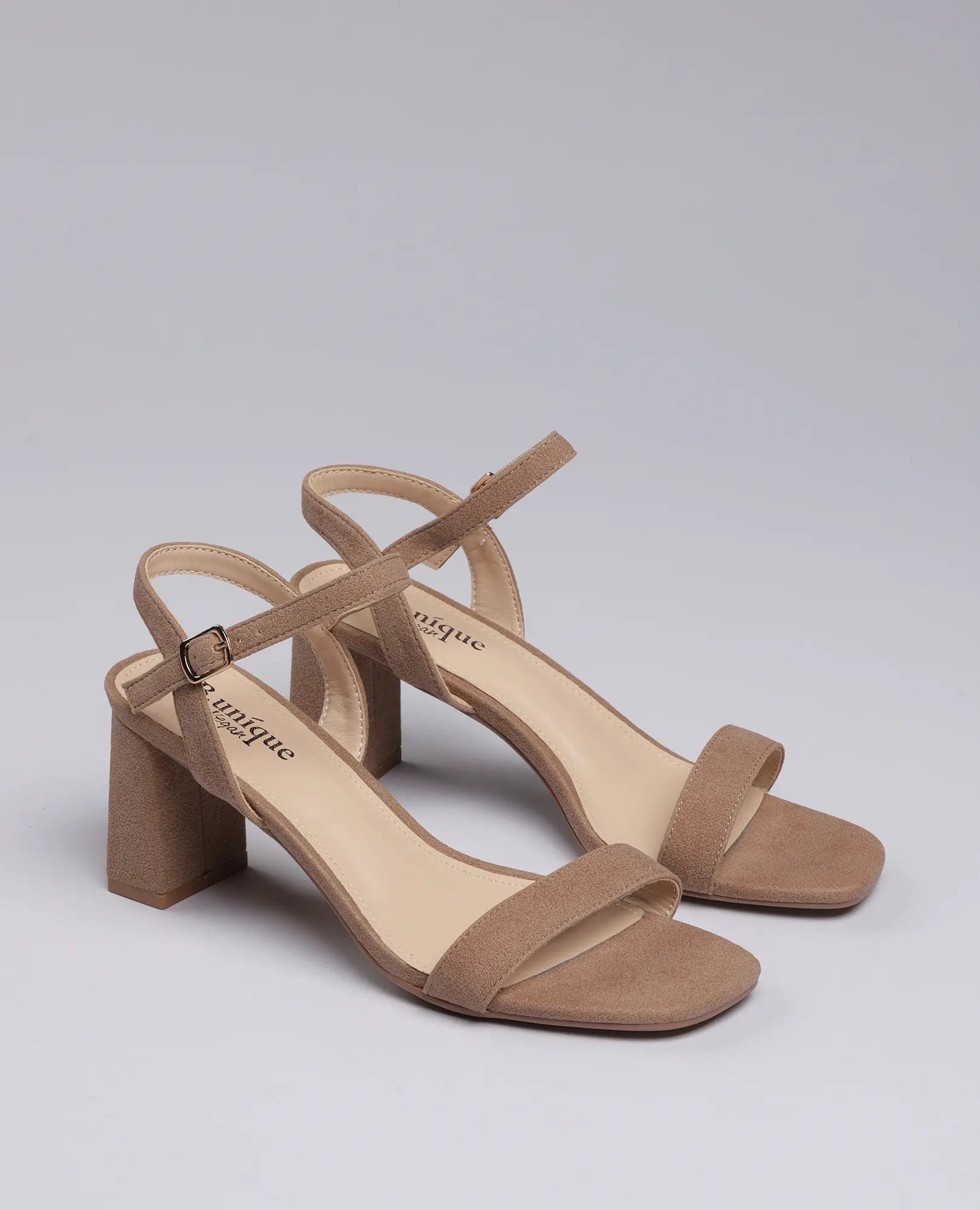 סנדלי עקב-אפריל של B-Unique VEGAN בצבע ניוד, עם עקב רחב ורצועות קרסול, מוצגות על רקע בהיר.