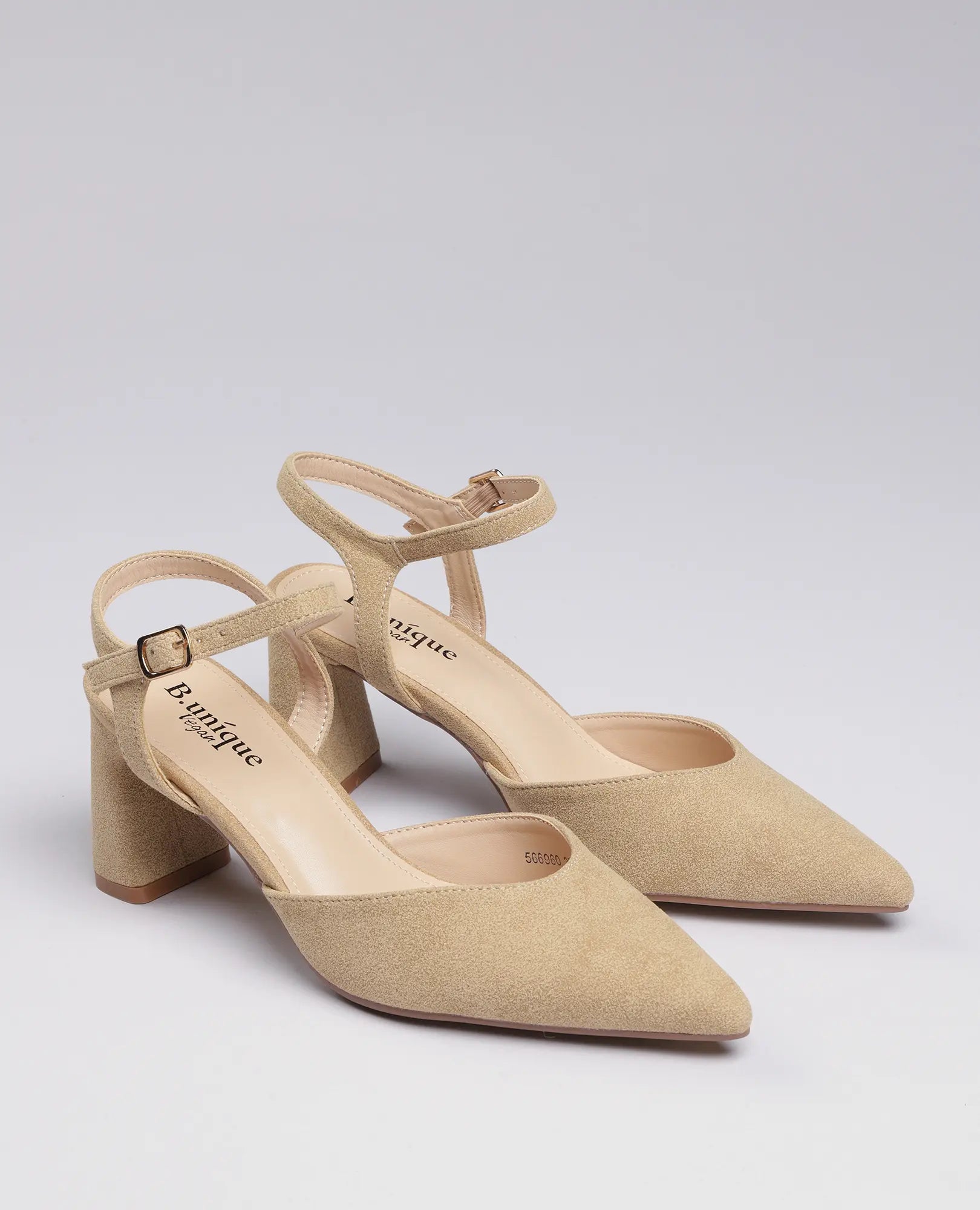 נעלי עקב "ארין" של B-Unique VEGAN, דמויות זמש בצבע בז', עם עקב בינוני ורצועות קרסול, מוצגות על רקע בהיר.