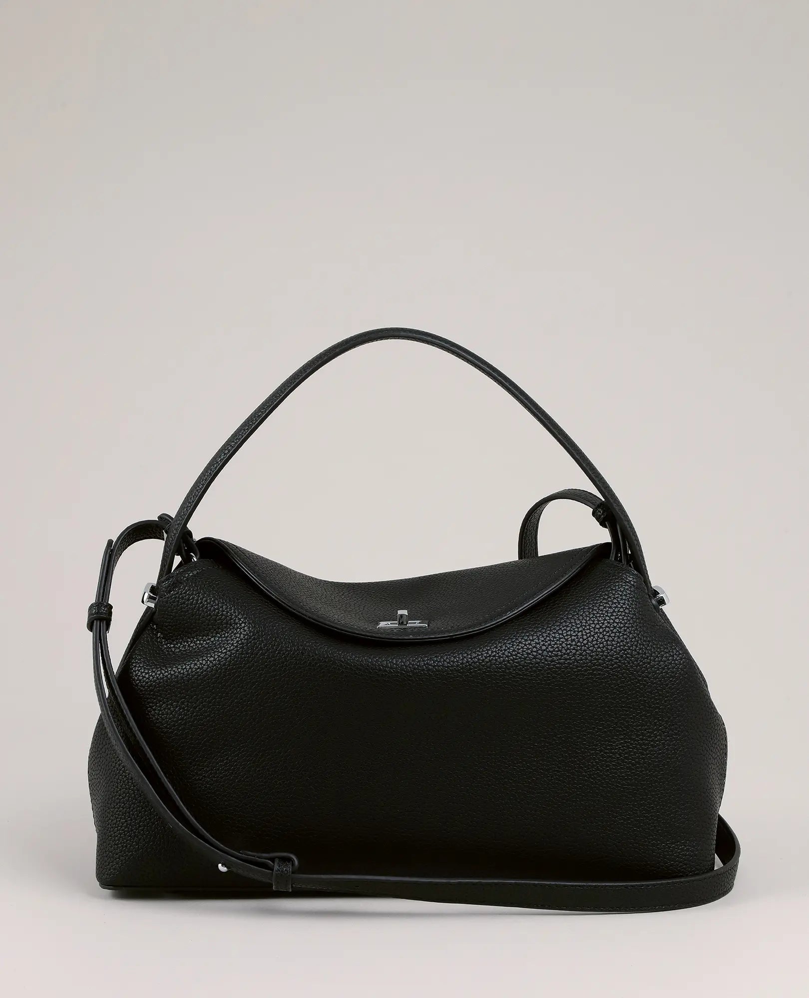 תיק הצד עם אבזם ומנעול מבית B-Unique Bags הוא תיק עור שחור עם ידית עליונה — מושלם בשילוב עם נעלי נשים.