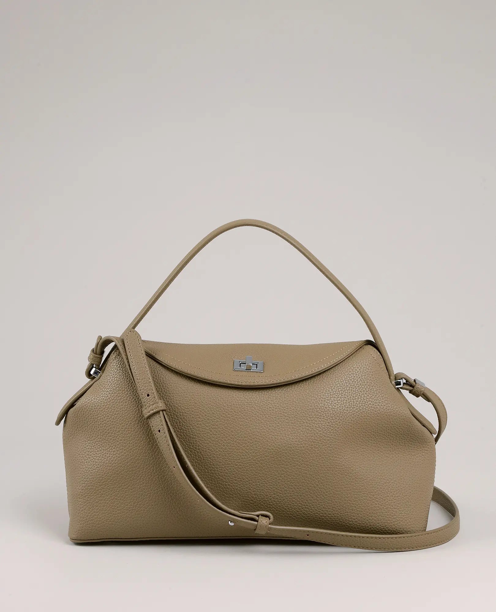 תיק צד עם אבזם ומנעול מבית B-Unique Bags בצבע טאופ, עם רצועה מתכווננת, ידית עליונה וסוגר כסוף.