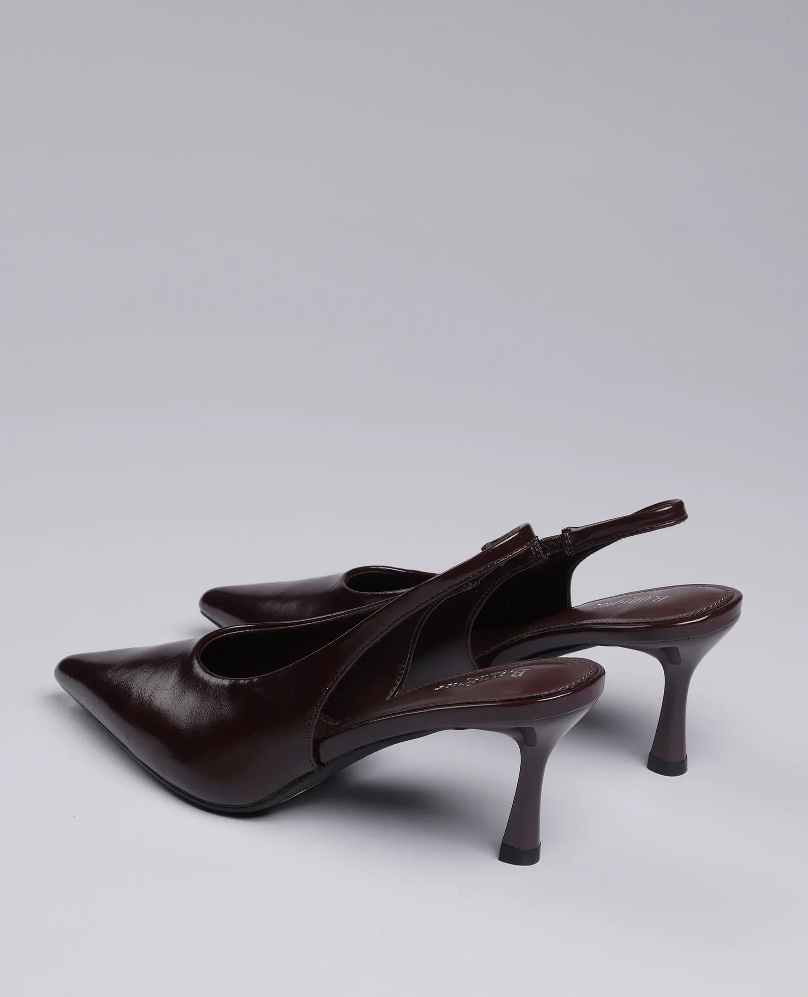 נעלי עקב שפיץ- דורון של B-Unique VEGAN, דמוי עור חום כהה עם רצועת Slingback, מוצגות על רקע אפור בהיר.