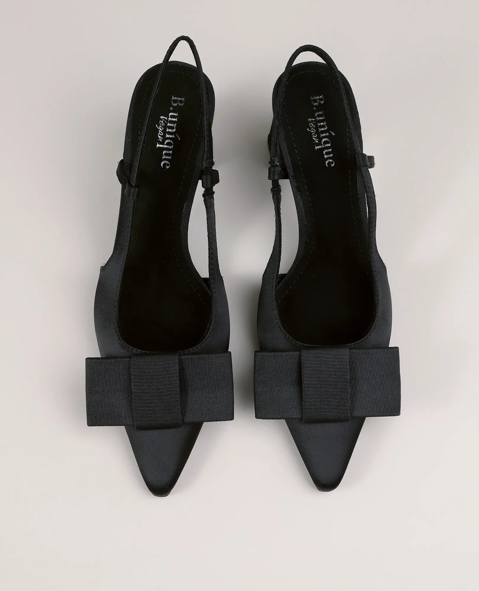 ה"סנדלי עקב פפיון-פלא" מבית B-Unique VEGAN הם סנדלי עקב שחורים עם קצה מחודד ועניבה אחורית, כפי שנראים מלמעלה.