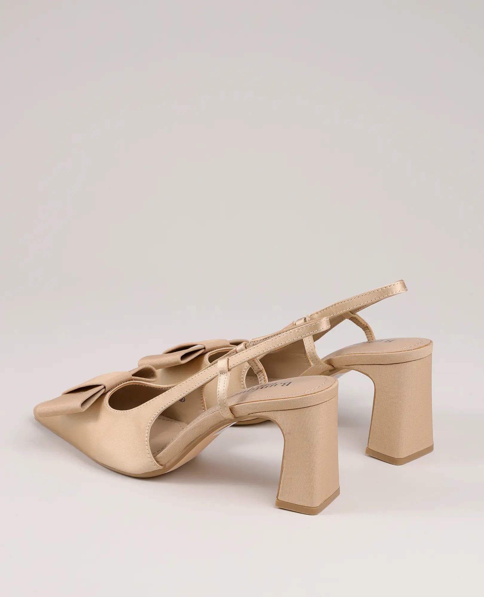 B-Unique VEGAN סנדלי עקב עם פפיון - פלא: סנדלי עקב בצבע בז' עם רצועה אחורית, קצה מרובע וקשתות על רקע בהיר.