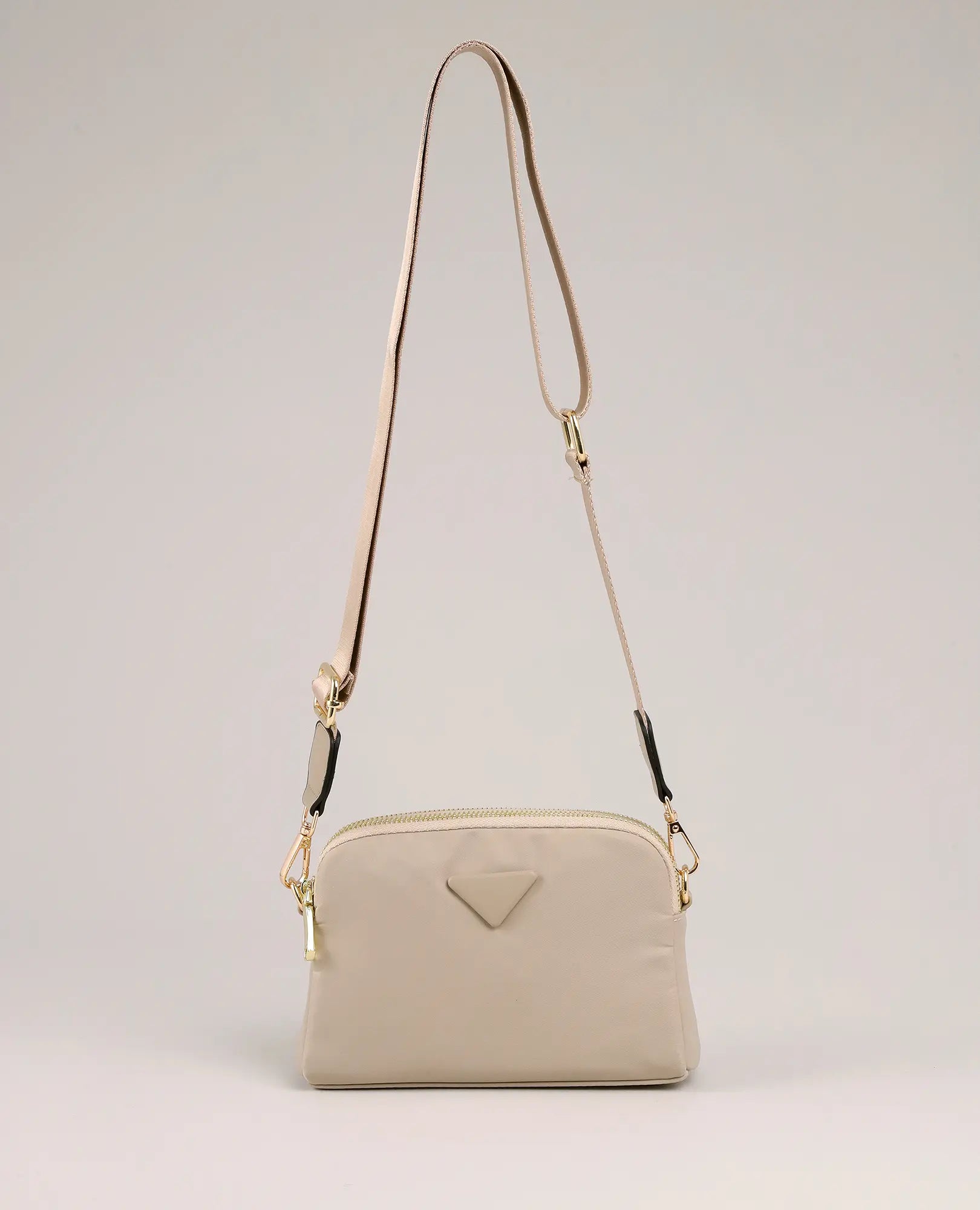 תיק צד - ויקטוריה מבית B-Unique Bags: קטן, שיקי, ניילון קשיח בצבע בז', רצועה דקה מתכווננת וקישוטי זהב.