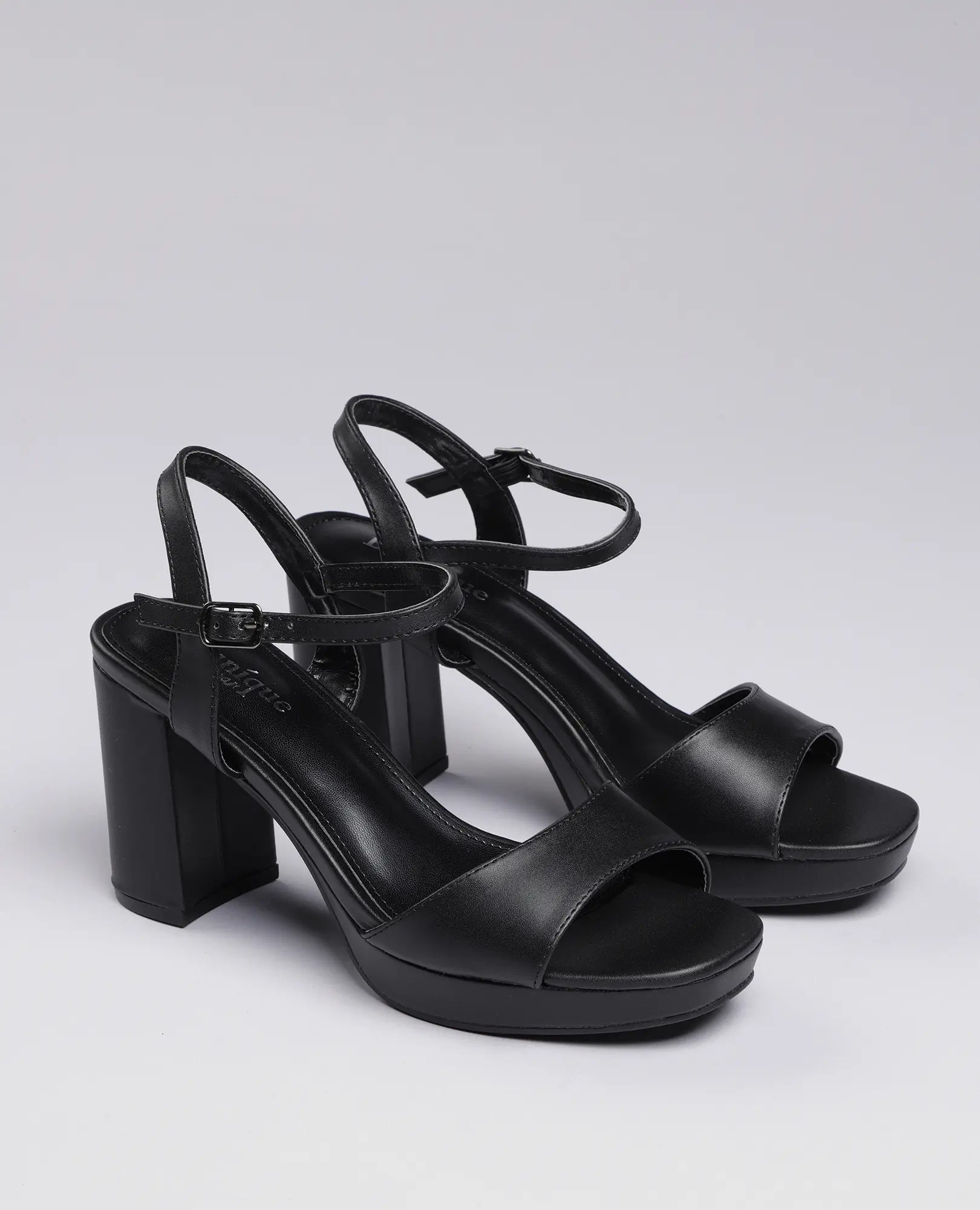 סנדלי פלטפורמה- אניטה של B-Unique VEGAN בצבע שחור, עם רצועות קרסול ועקב רחב, מוצגים על רקע אפור בהיר.