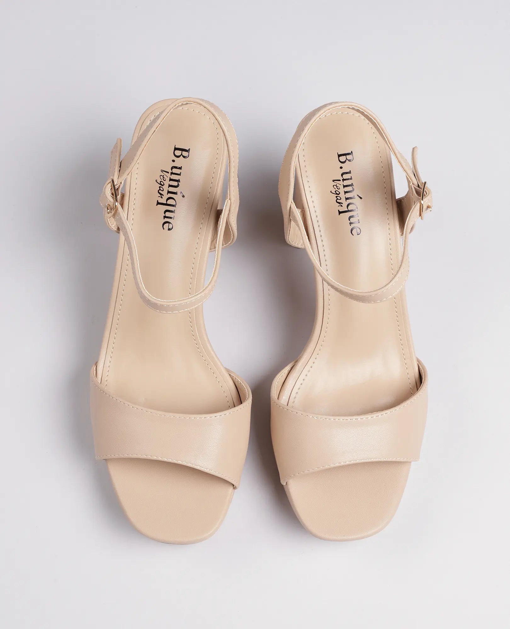 סנדלי פלטפורמה- אניטה מבית B-Unique VEGAN, דמוי עור בצבע בז', עם עקב רחב ורצועות קרסול על רקע לבן.