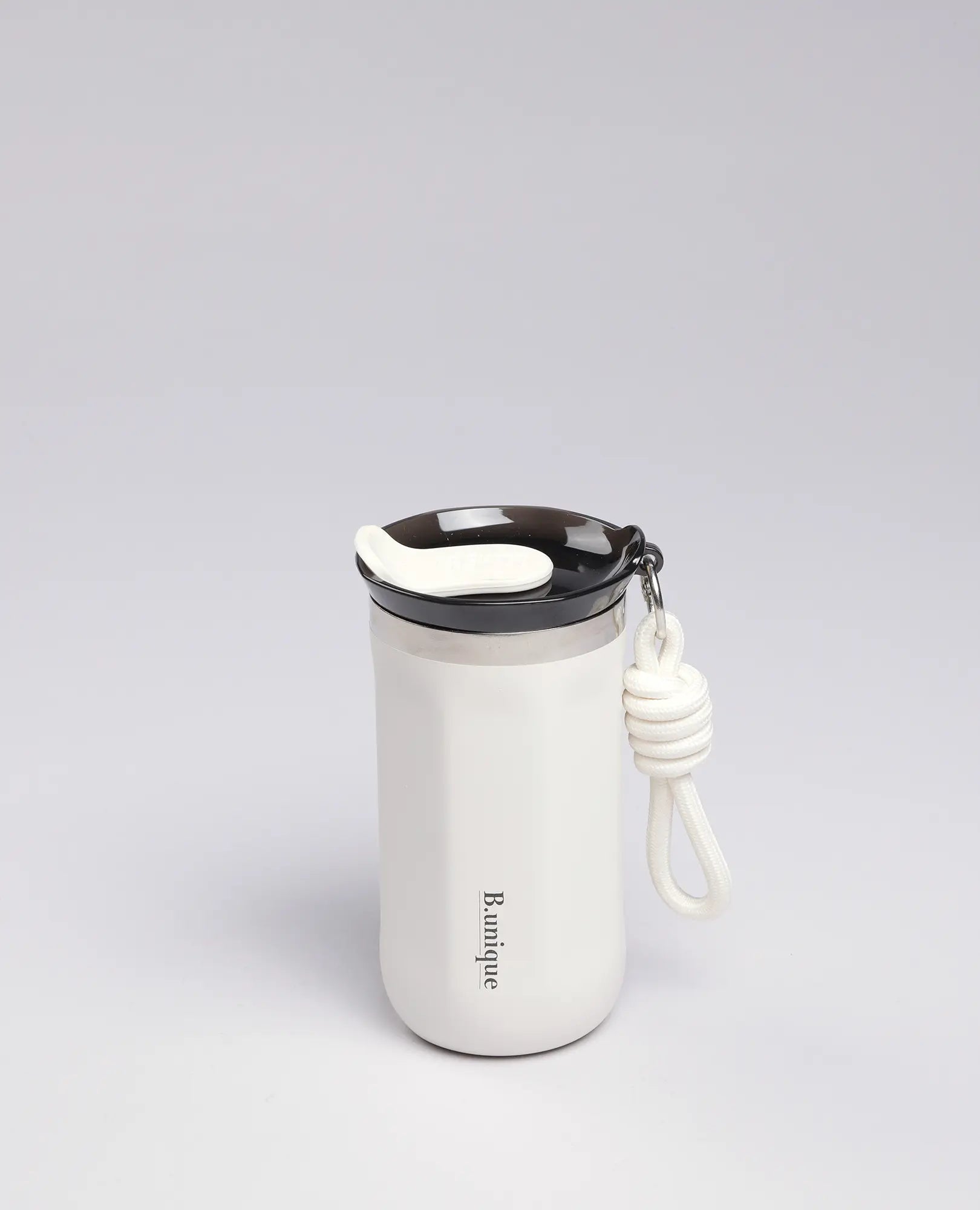כוס תרמית 350 מ"ל של B Unique בצבע קרם עם מכסה שחור, ידית ולולאת חבל, על רקע אפור בהיר.