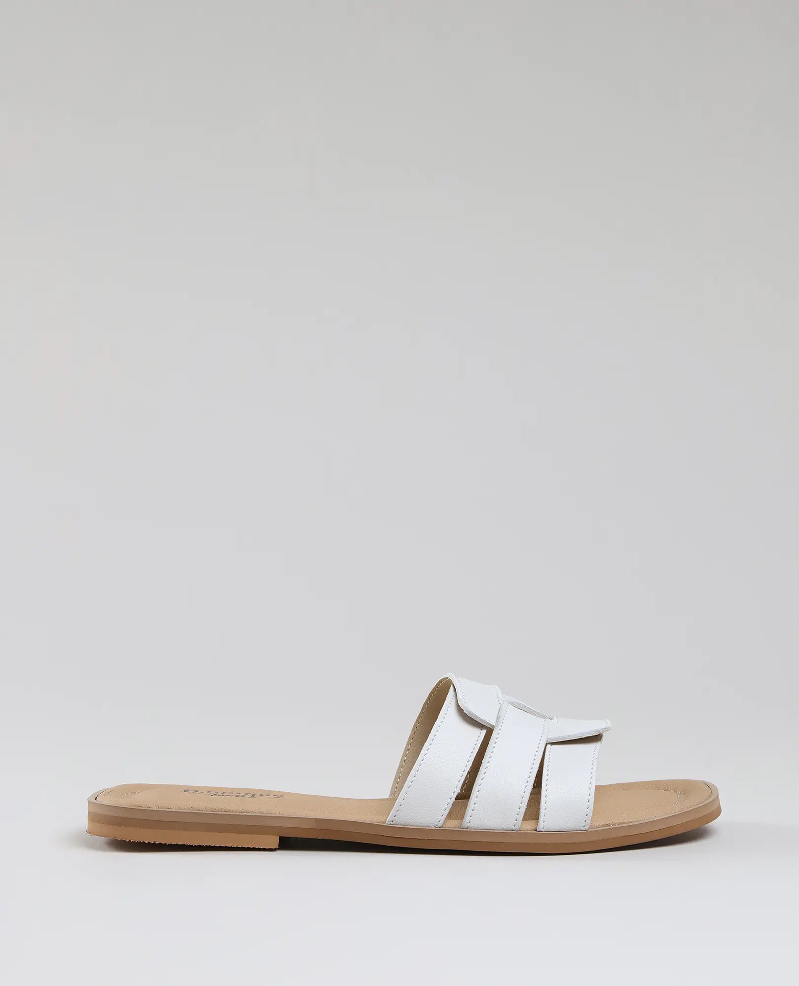 כפכפי רצועות-סקאיי של B.unique: כפכף שטוח בצבע לבן מעור איכותי, עם שלוש רצועות רחבות וסוליה בגוון חום בהיר, על רקע אפור בהיר.