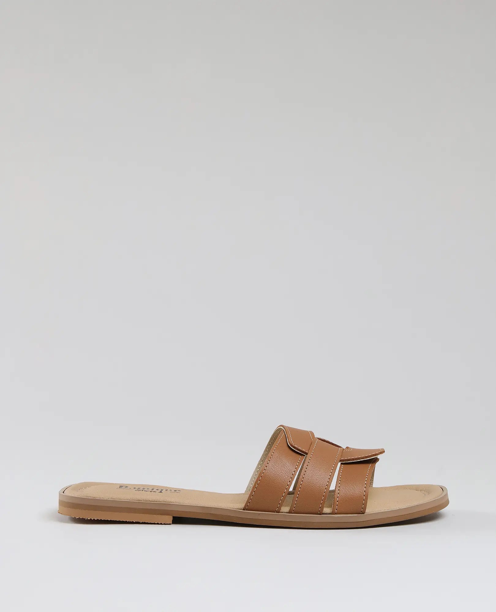 כפכפי רצועות - סקיי בעיצוב שטוח משתי רצועות עור איכותי מבית B.unique, מוצגים בפרופיל על רקע בהיר.