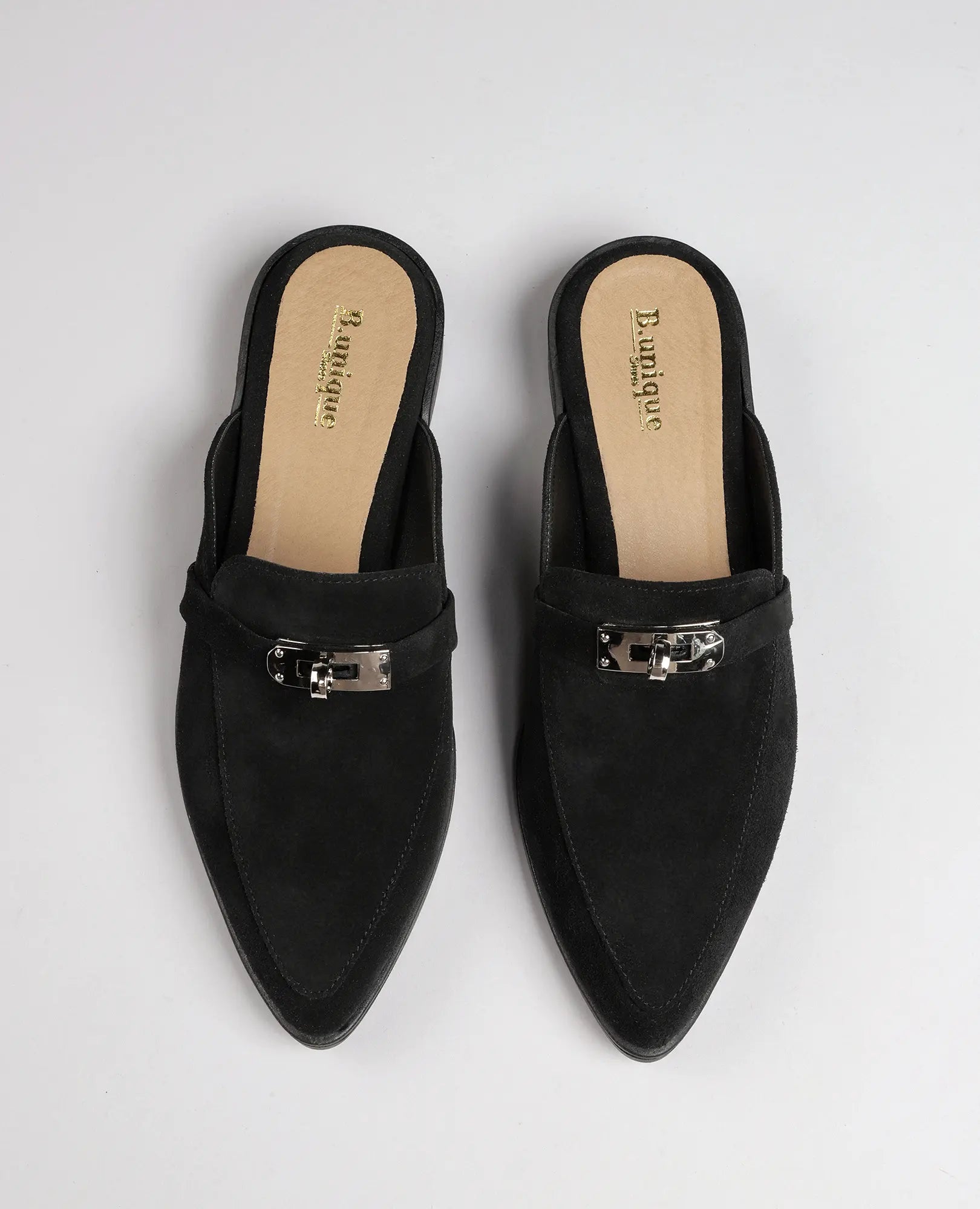 זוג כפכפי מוקסין-ניקי שחורים של B.unique, עור זמש, נעלי מוקסין עם אצבע מחודדת ואבזמי כסף, במבט מלמעלה.