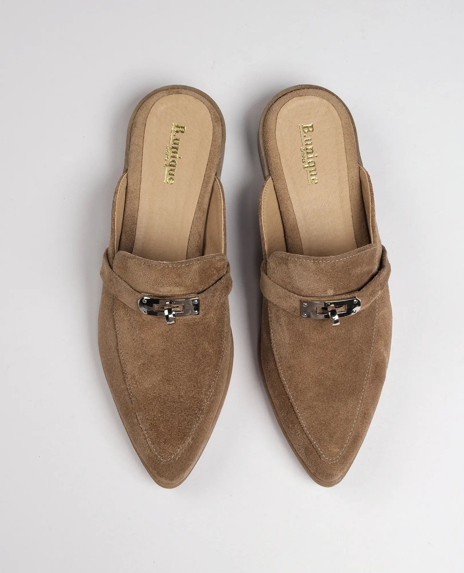 זוג כפכפי מוקסין-ניקי מזמש חום בהיר של B.unique עם אבזמי כסף, נראים מלמעלה על רקע בהיר.