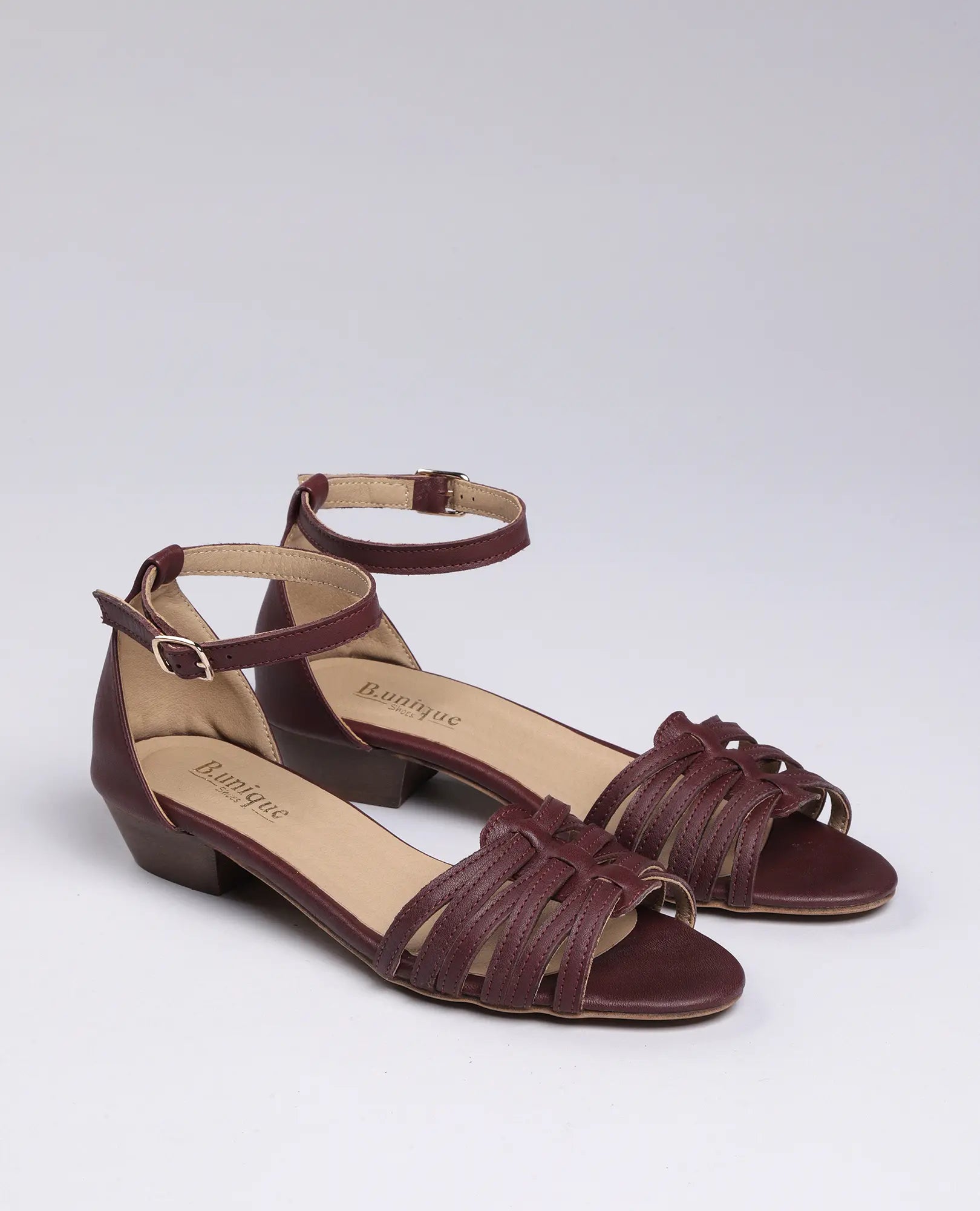 סנדלי רצועות דקות מבית B.unique לנשים, בצבע בורדו, בעיצוב קלוע ואלגנטי.