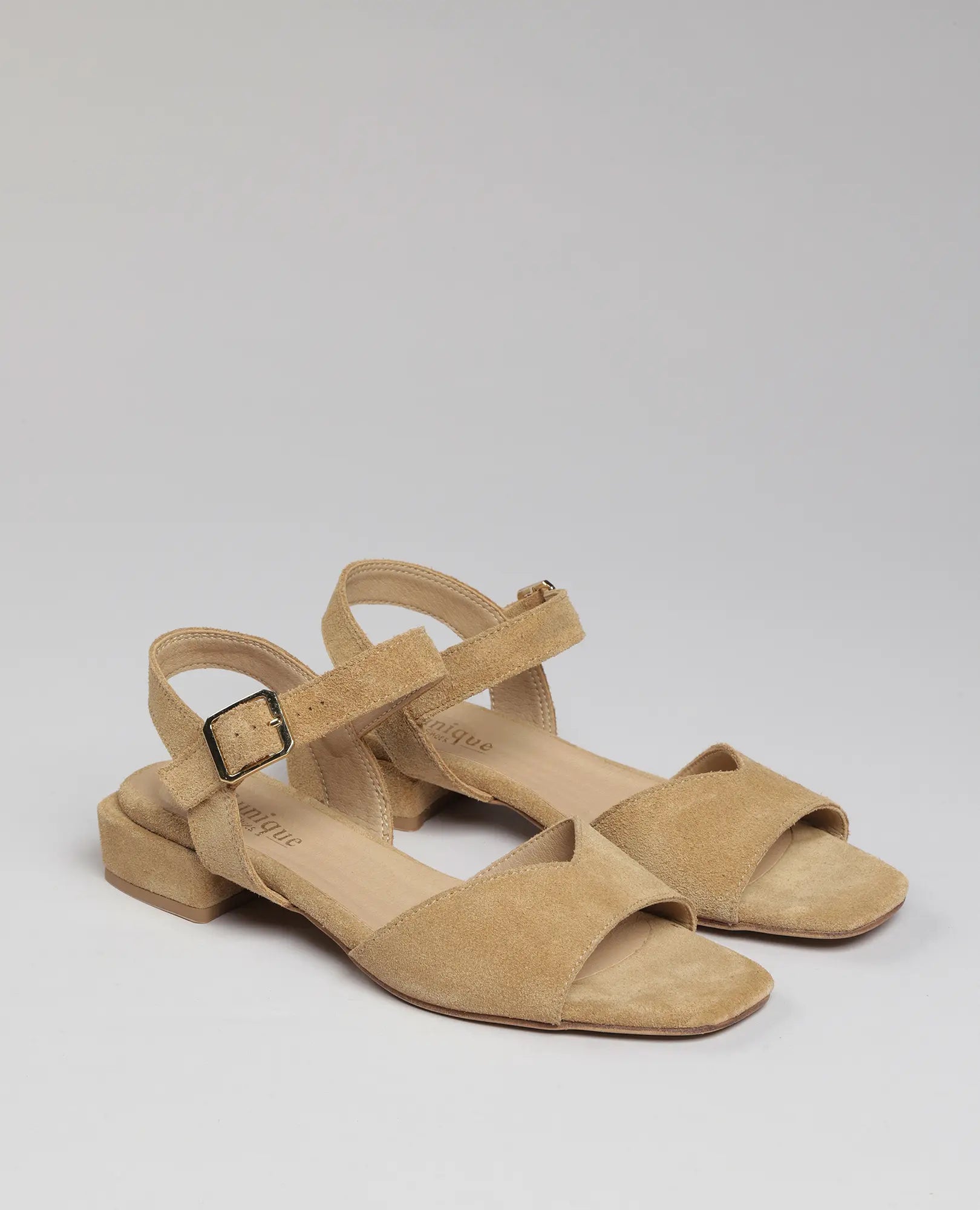 זוג סנדלים לנשים של B.unique – ניר בצבע קאמל עם רצועות קרסול, מוצגות על רקע בהיר.