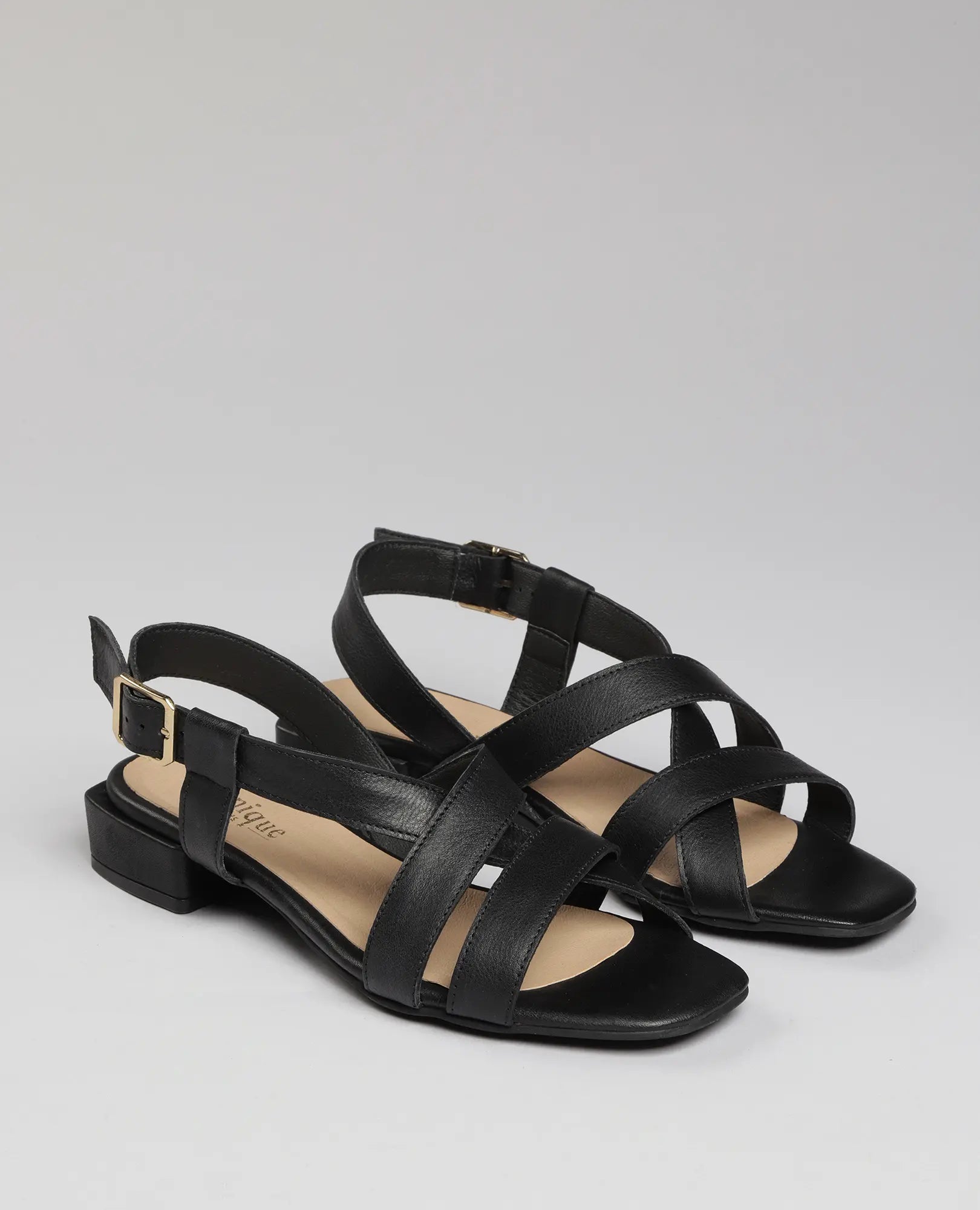 סנדלים שטוחות מדגם "נלה" של B.unique בצבע שחור, מוצגות על רקע אפור.