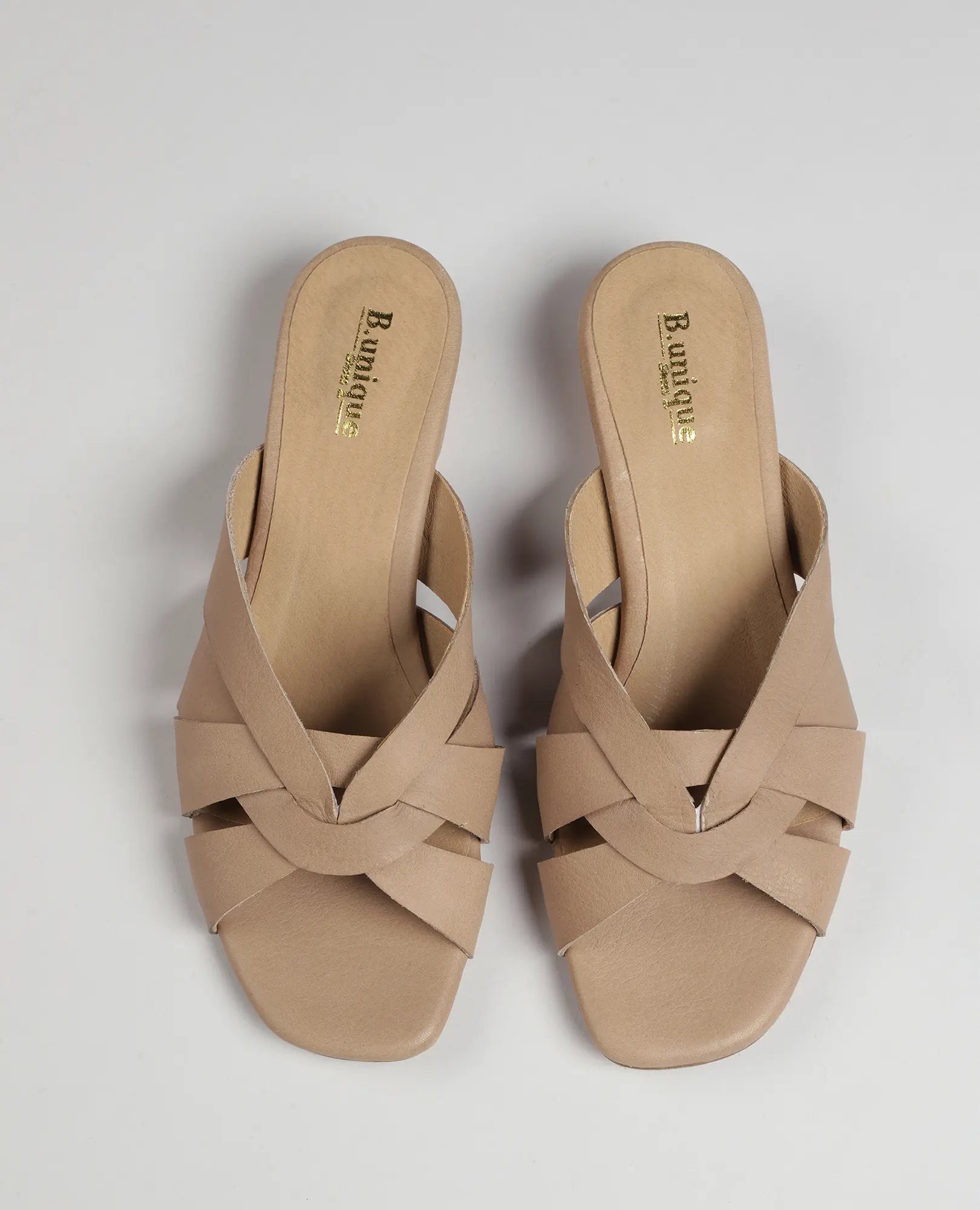 כפכף עם רצועות משולבות – דגם "סאלי" של B.unique בגוון בז', בעיצוב עם עקב פתוח ורצועות עור משולבות למראה אלגנטי.