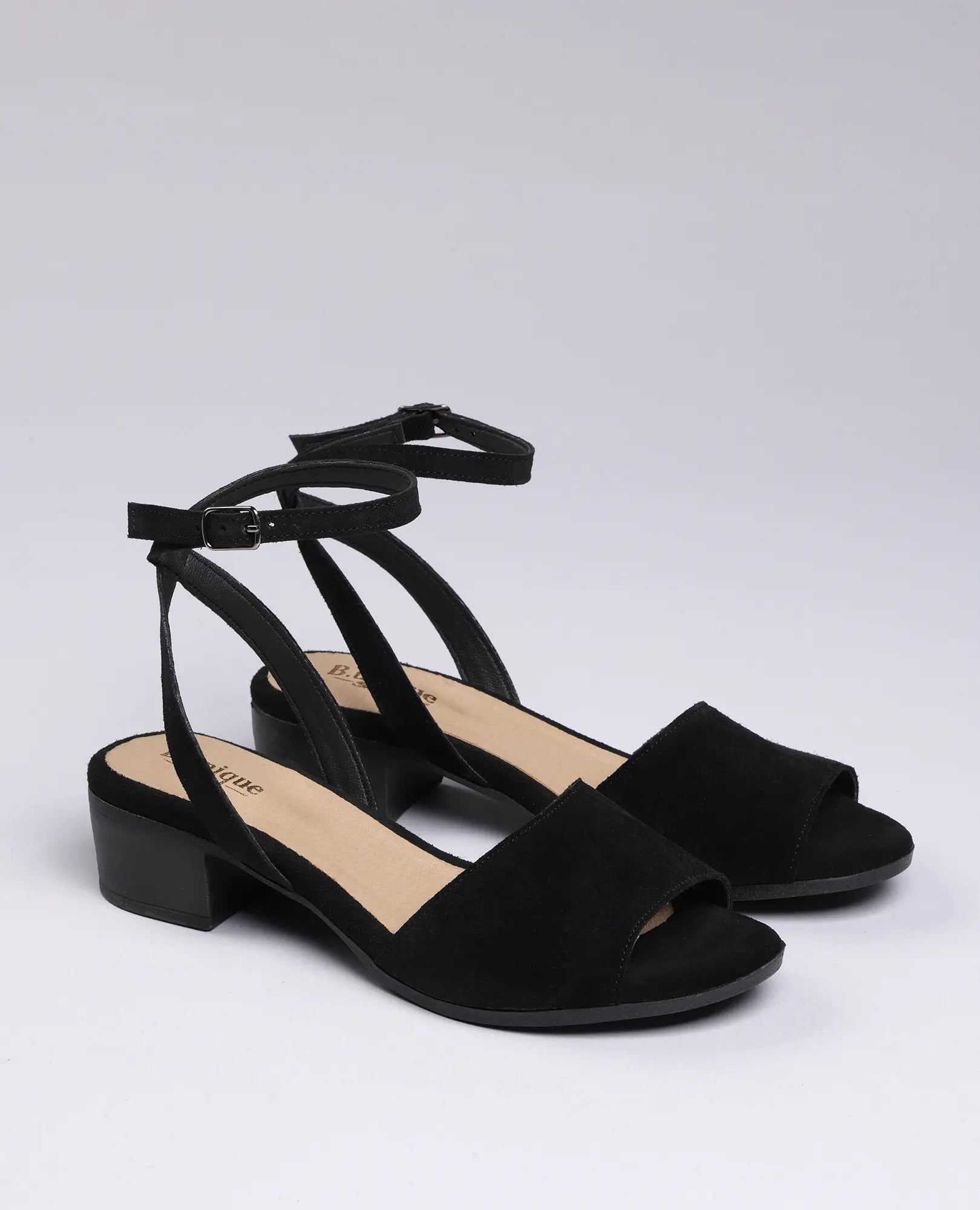 זוג סנדלי פלה זמש-סנואו של B.unique, סנדלים פתוחים עם עקב נמוך, רצועות בקרסול ואבזמים.