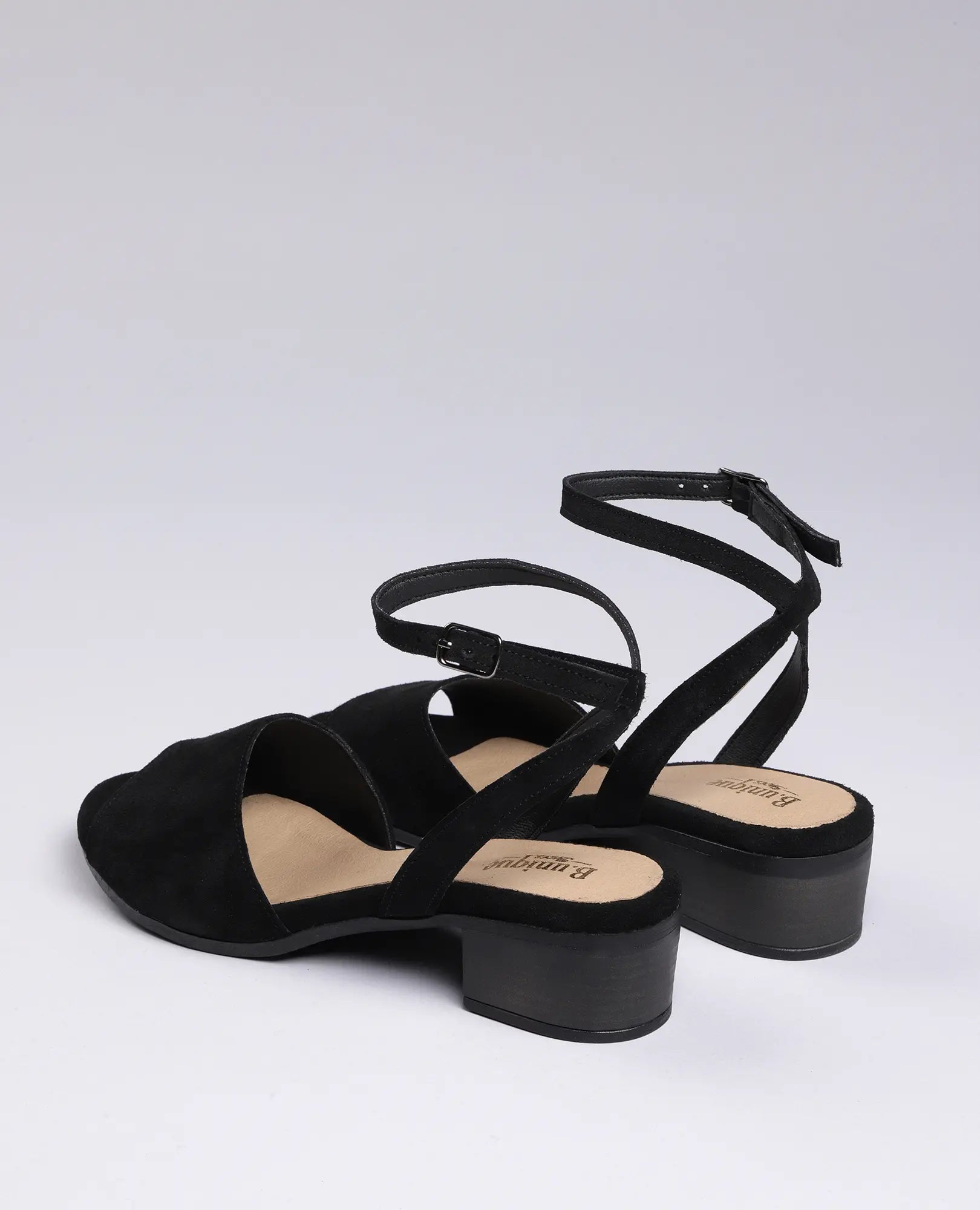 סנדלי פלה מזמש - "סנואו" של B.unique, בצבע שחור, עם עקב נמוך ורצועת קרסול עם אבזמים, מוצגים על רקע לבן.